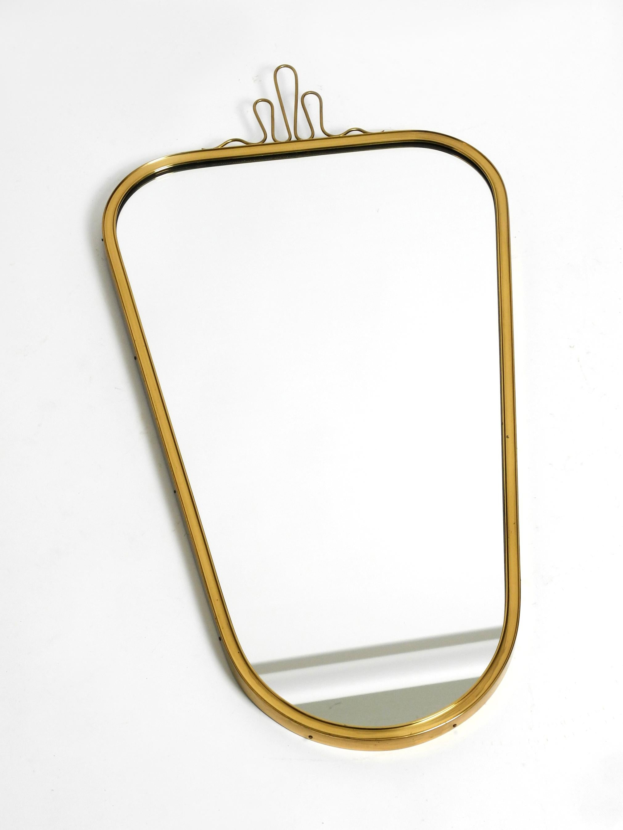 Beautiful heavy Mid Century Modern brass wall mirror from Münchner Zierspiegel.
Made in Germany. Great 1950s minimalist very elegant design.
Very high quality and elegantly processed.
A large brass crown is screwed onto the top.
Heavy and very