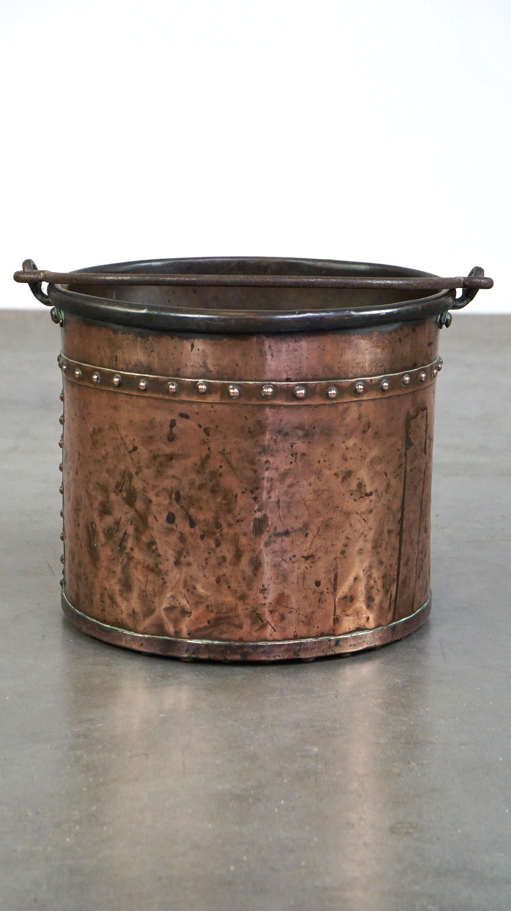 This stunning antique Frisian nailed red copper bucket dates back to the early 19th century. It is full of original and unique details, making it a true eye-catcher. You can place it by the fireplace at home and use it for your firewood, as a purely