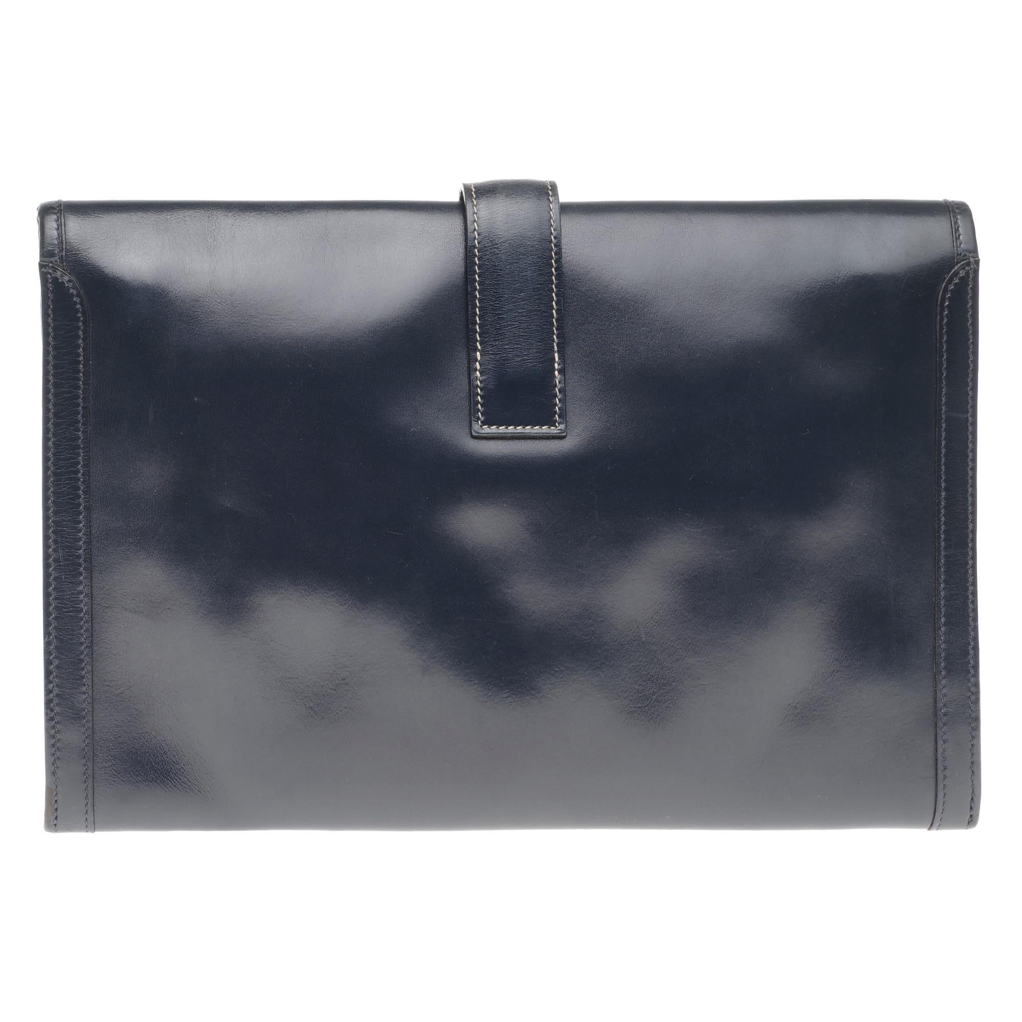 Beautiful clutch Hermes Jige in navy blue box leather, white stitching, handmade.

Closure H on flap.
Interior lining in beige canvas.
Signature: 