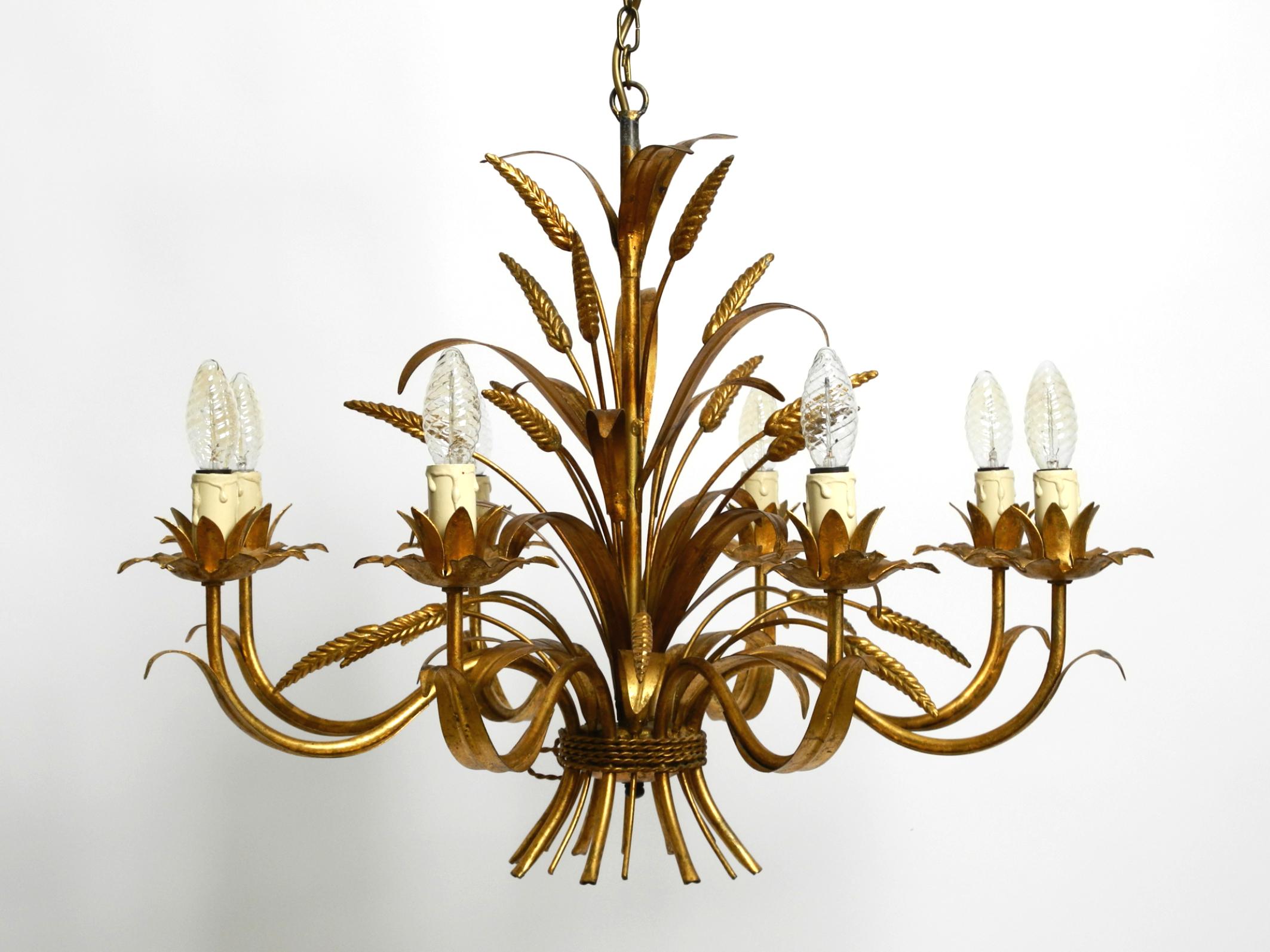 Beautiful 1970s gold-plated 8-arm metal chandelier by Hans Kögl.
Hans Kögl was a famous lighting and table designer. He worked with natural shapes such as palm leaves and other plant forms. His designs were produced in both Germany and
