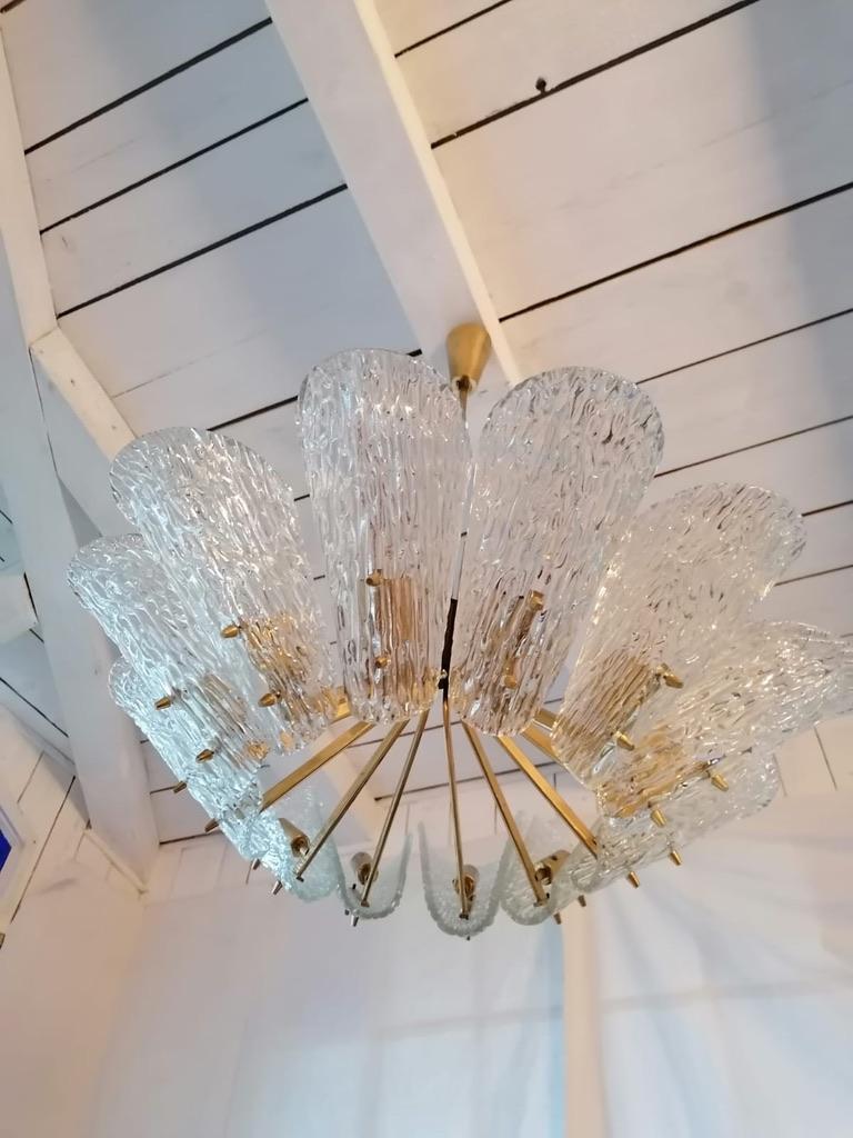 Construcción de latón con 12 brazos y pantallas de cristal texturizado, provistas de casquillos E14. Fabricado en Austria en la década de 1950 J.T. Kalmar Viena.
 