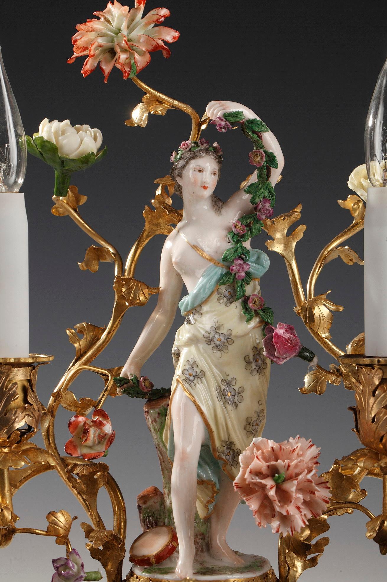 Charming Louis XV style polychrome porcelain and gilded bronze inkwell attributed to L'Escalier de crystal, with a muse holding a garland of flowers, on both sides two covered cups, in the center a receptacle with an openwork top, the whole framed