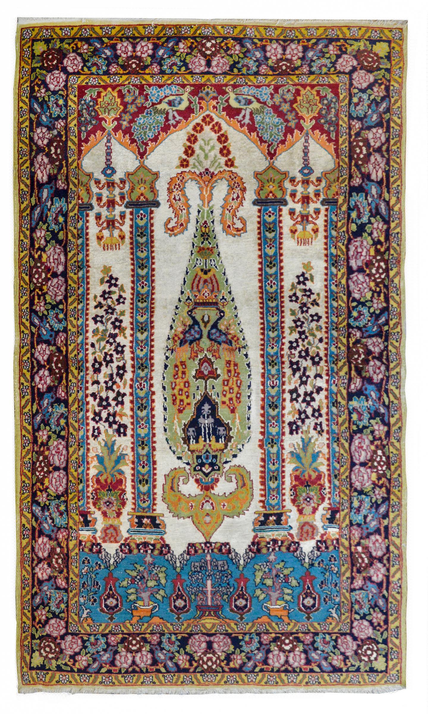 A beautiful mid-20th century Persian Isfahan prayer rug with an architectural elements like columns, chandeliers, and pointed arches, all with myriad flowers, vines, and potted plants, with peacocks and other birds, woven in myriad colors. The
