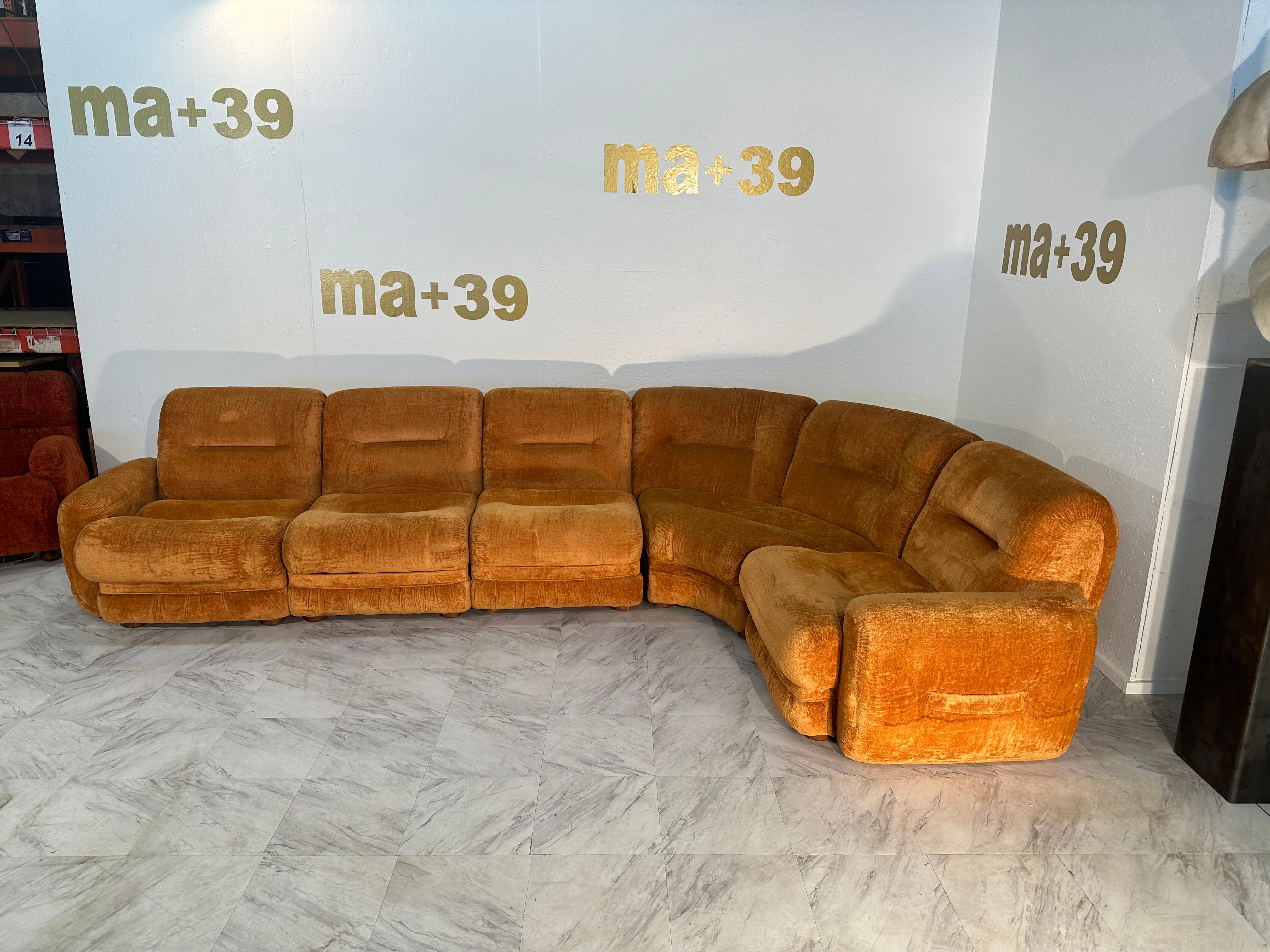 Ce magnifique canapé sectionnel italien du milieu du siècle dernier, datant des années 1980, est une pièce étonnante qui incarne l'esthétique du design de cette époque. Le canapé arbore son tissu orange d'origine, ajoutant une touche vibrante et