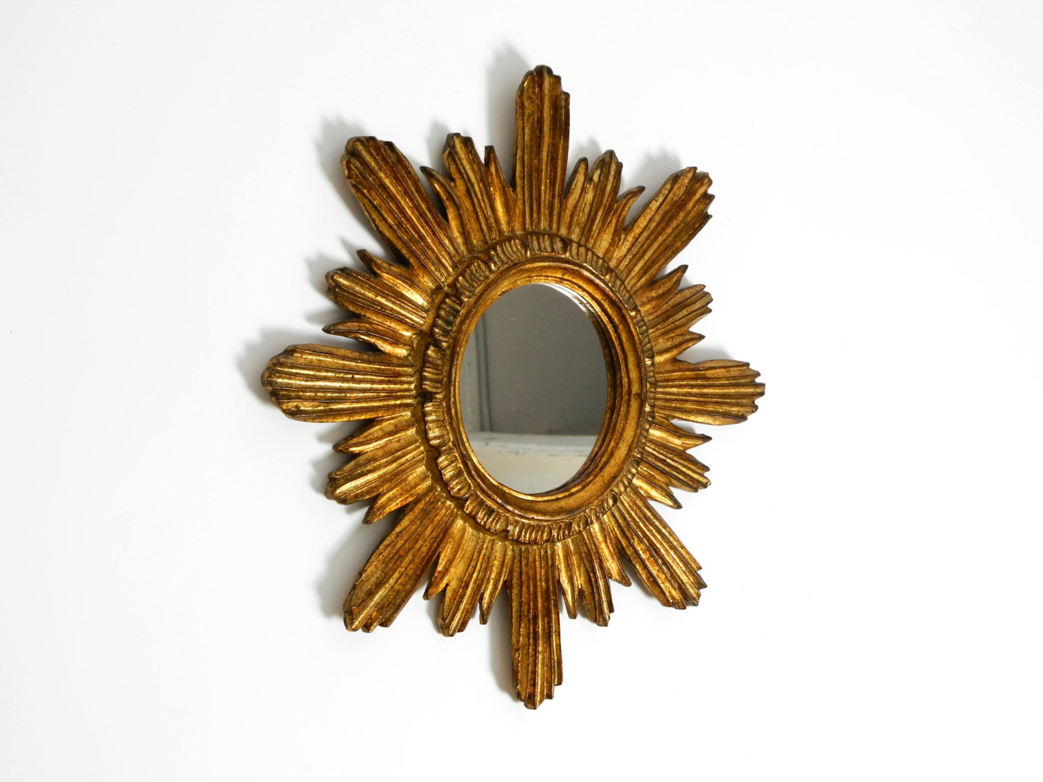 Beautiful Italian Mid Century Modern sunburst wall mirror made of wood and resin, gold-plated.
Great 1950s design.
No damage to the frame. Mirror without scratches and not blind.
Cleaned and ready to live in. Very good vintage condition with a light