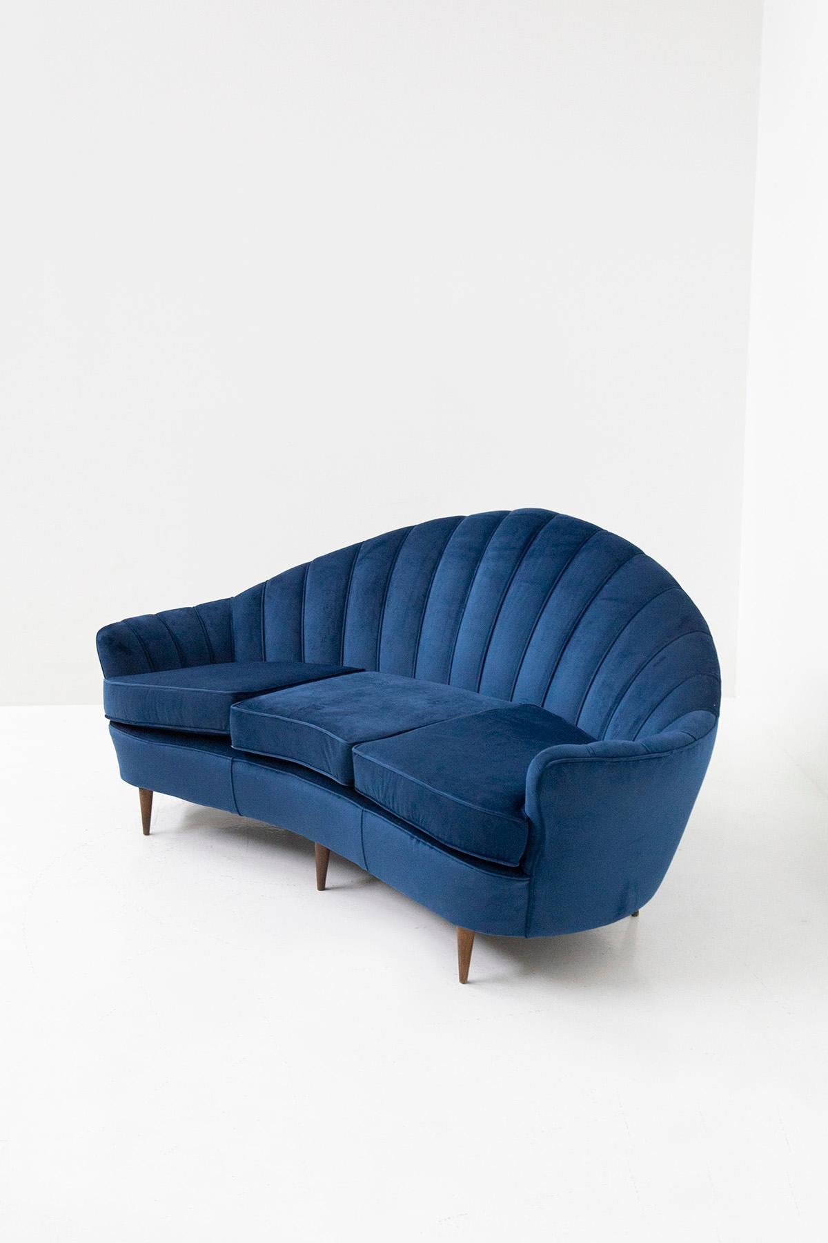 Elegant Italian sofa from the 1950s. The sofa features a shell-shaped design typical of the midcentury. the sofa has recently been refurbished with an elegant blue velvet. Their main feature is the shell-shaped backrest, beautifully taken up and