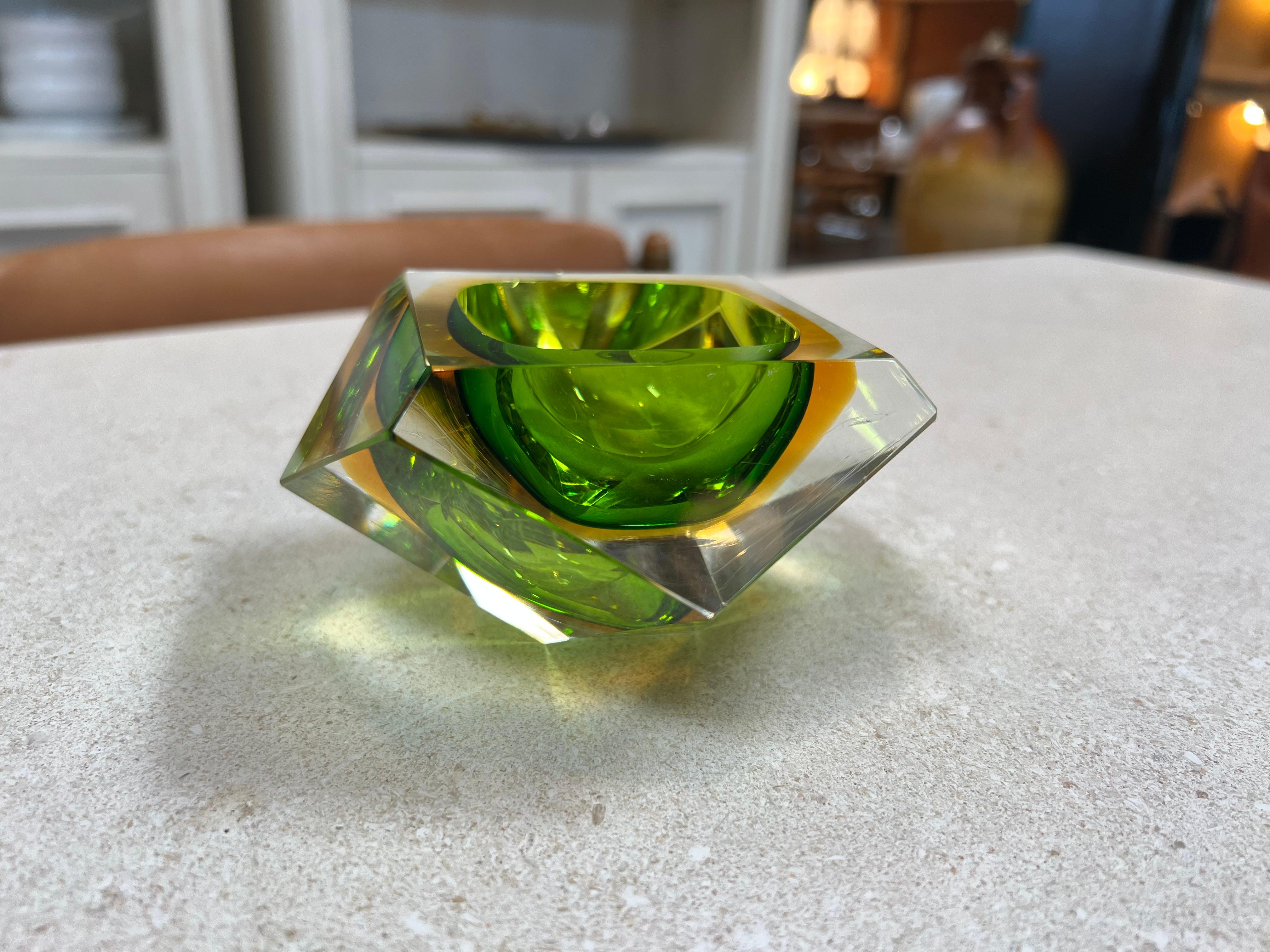Le magnifique cendrier italien en verre vert submergé des années 1960 est une pièce captivante qui dégage un sentiment de tranquillité et de sophistication. Fabriqué avec soin, ce cendrier présente un design envoûtant avec un verre teinté en vert