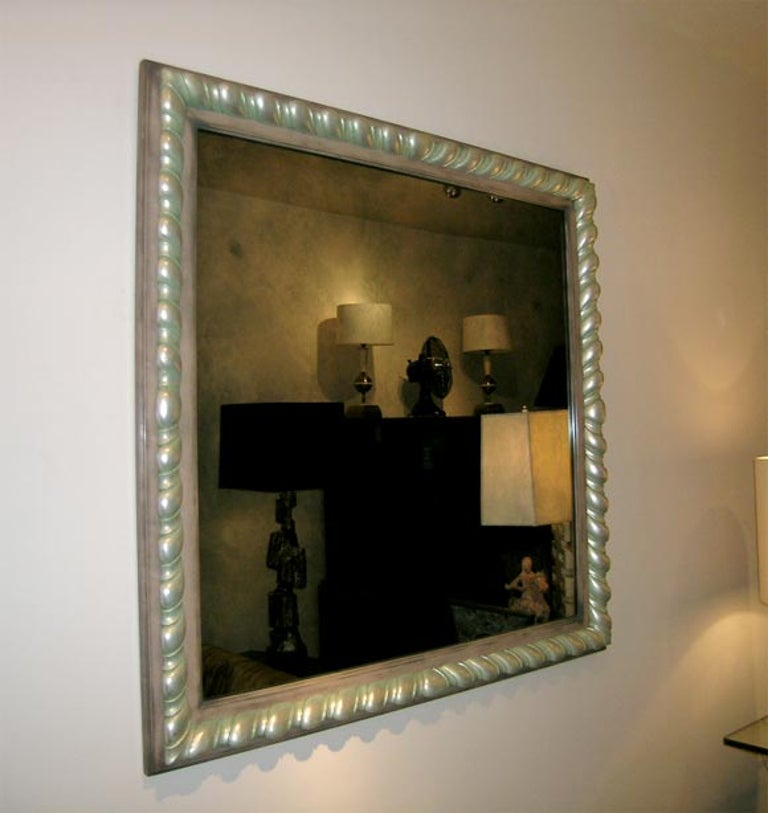 Spectacular James Mont mirror with a wonderful carved frame in the original silver celadon finish. The mirror itself has an antique patina.