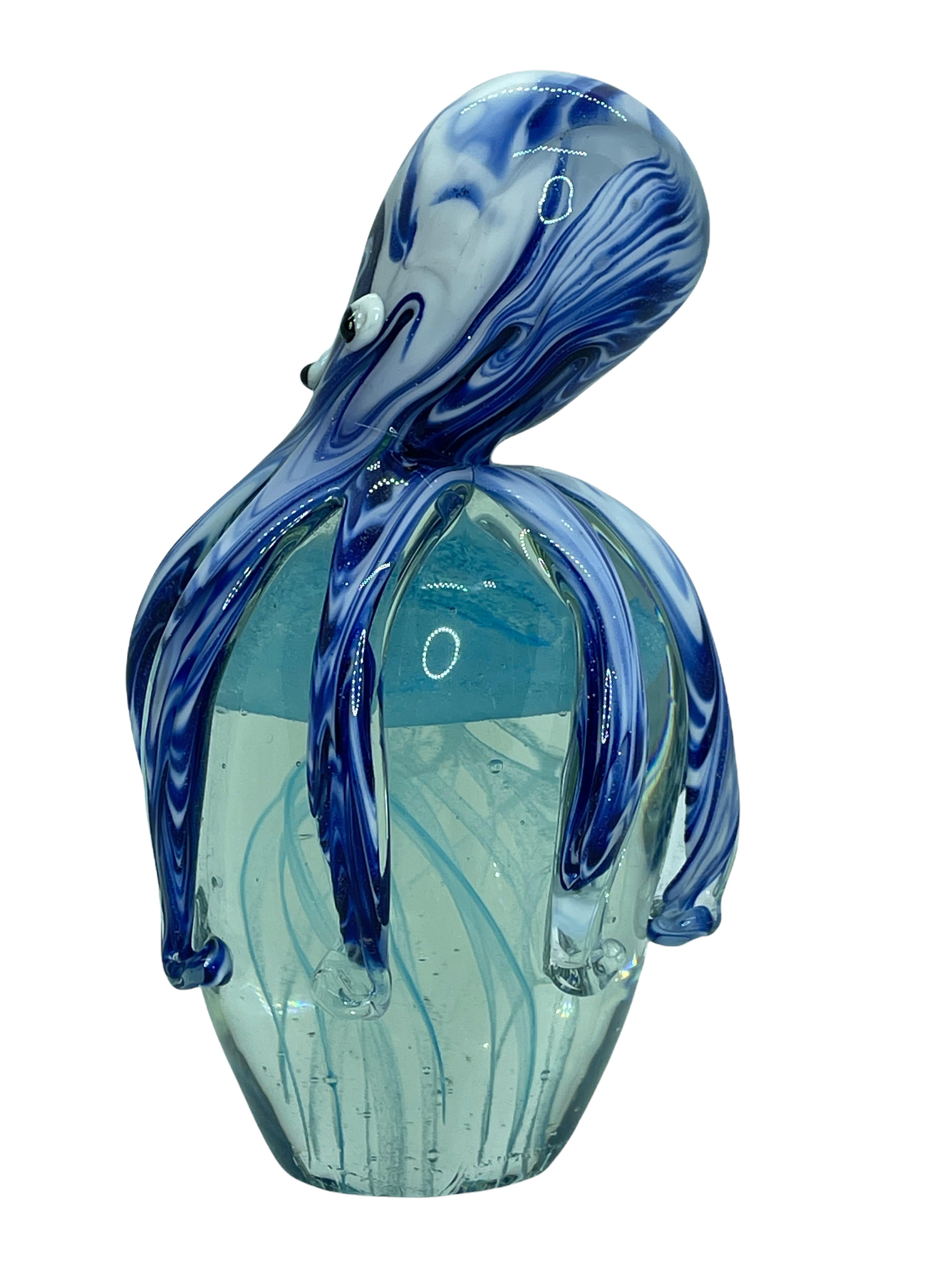 Beautiful Murano hand blown aquarium Italian art glass paper weight. Showing a octopus holding a jelly fish, underwater floating on controlled bubbles inside. Colors are a blue, white, black and clear. A beautiful nice addition to your desktop or as