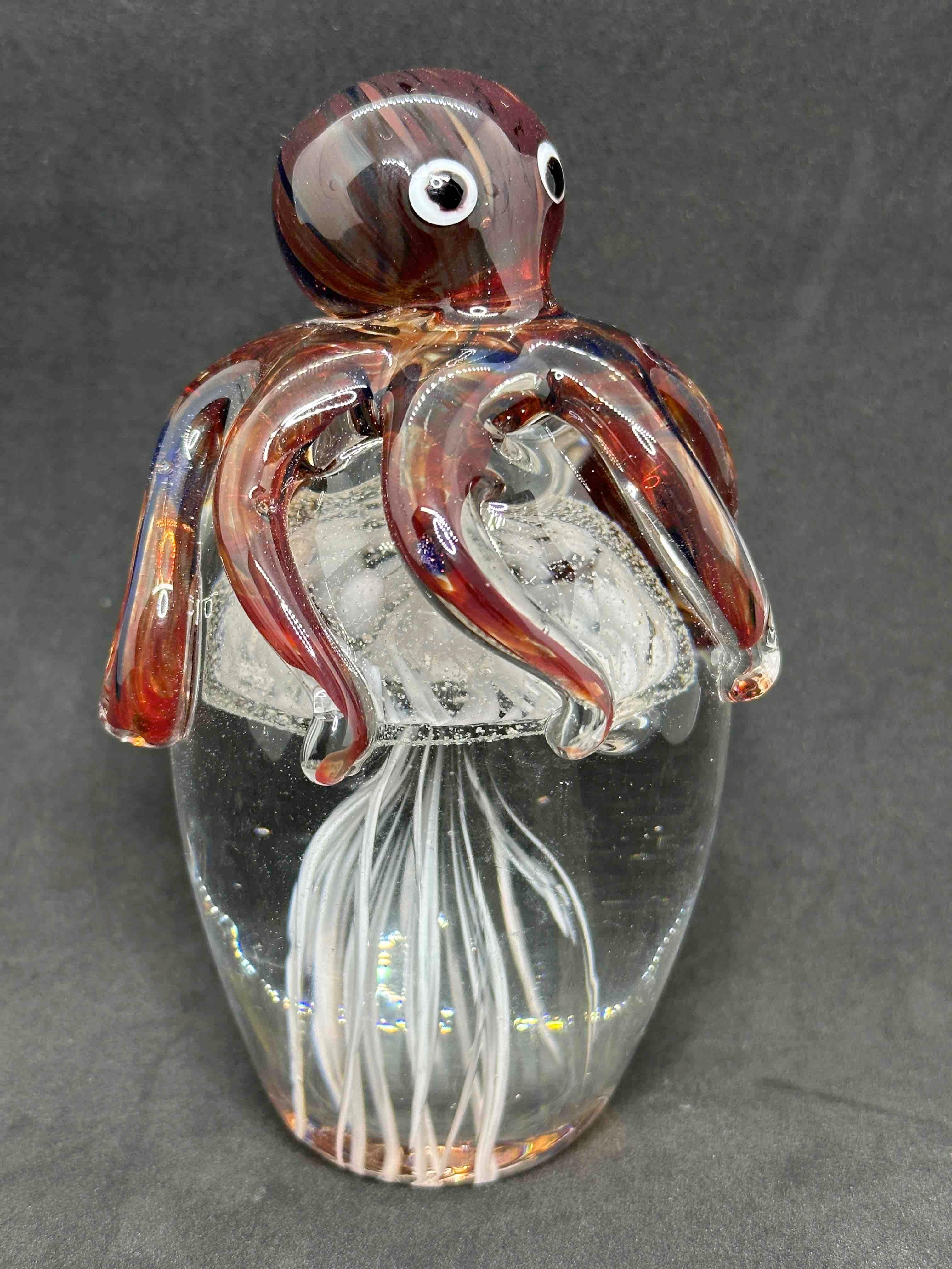 Beautiful Murano hand blown aquarium Italian art glass paper weight. Showing a octopus holding a jelly fish, underwater floating on controlled bubbles inside. Colors are a brown, white, blue, black and clear. A beautiful nice addition to your