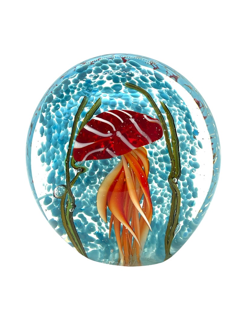 Beautiful Murano hand blown aquarium Italian art glass paper weight. Showing a jellyfish, underwater floating on controlled bubbles inside a reef with seaweed. Colors are a blue, green, red, orange and clear. A beautiful nice addition to your