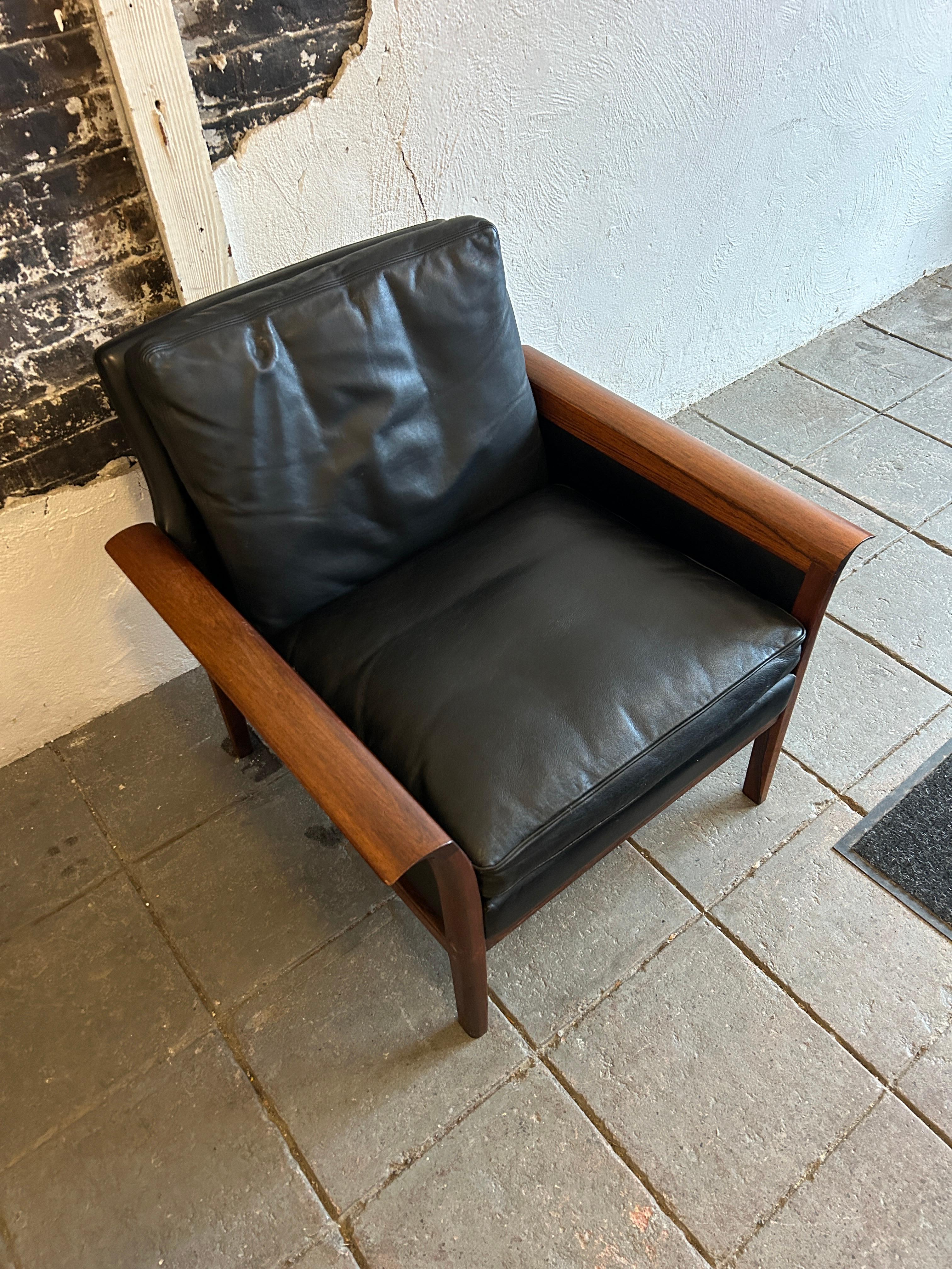Beautiful Knut Saeter for Vatne Mobler black leather and rosewood lounge chair. All original black leather upholstery worn in nicely. Stunning rosewood curved arms and legs. Very solid Black Leather chair. Labeled - Vatne Mobler. Made in Norway.