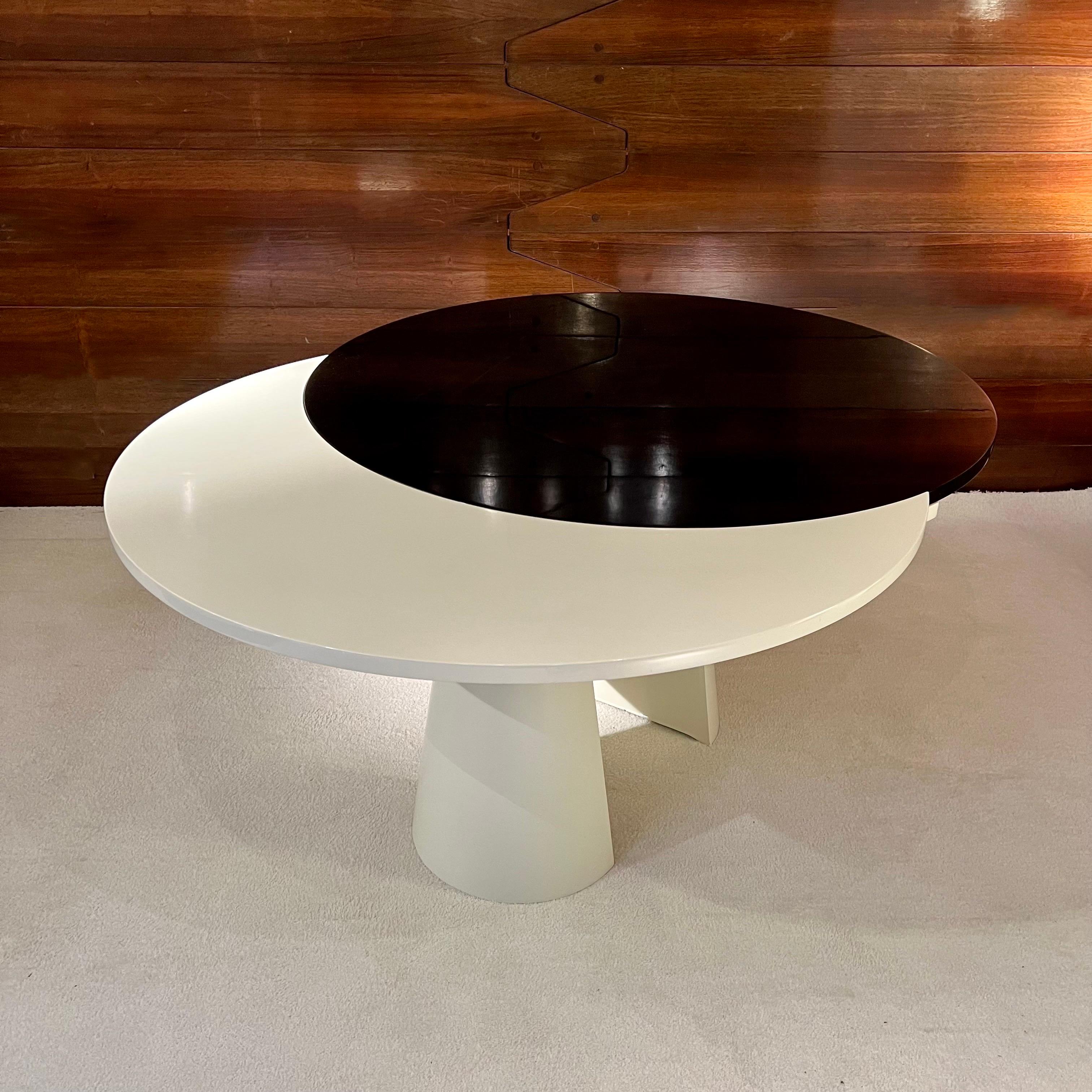 Dieser herrliche Tisch, der in den 80er Jahren in Frankreich hergestellt wurde, hat zwei lackierte Platten, eine schwarze und eine weiße. Durch das ausgeklügelte Verlängerungssystem lässt er sich von einem runden in einen ovalen Tisch verwandeln.