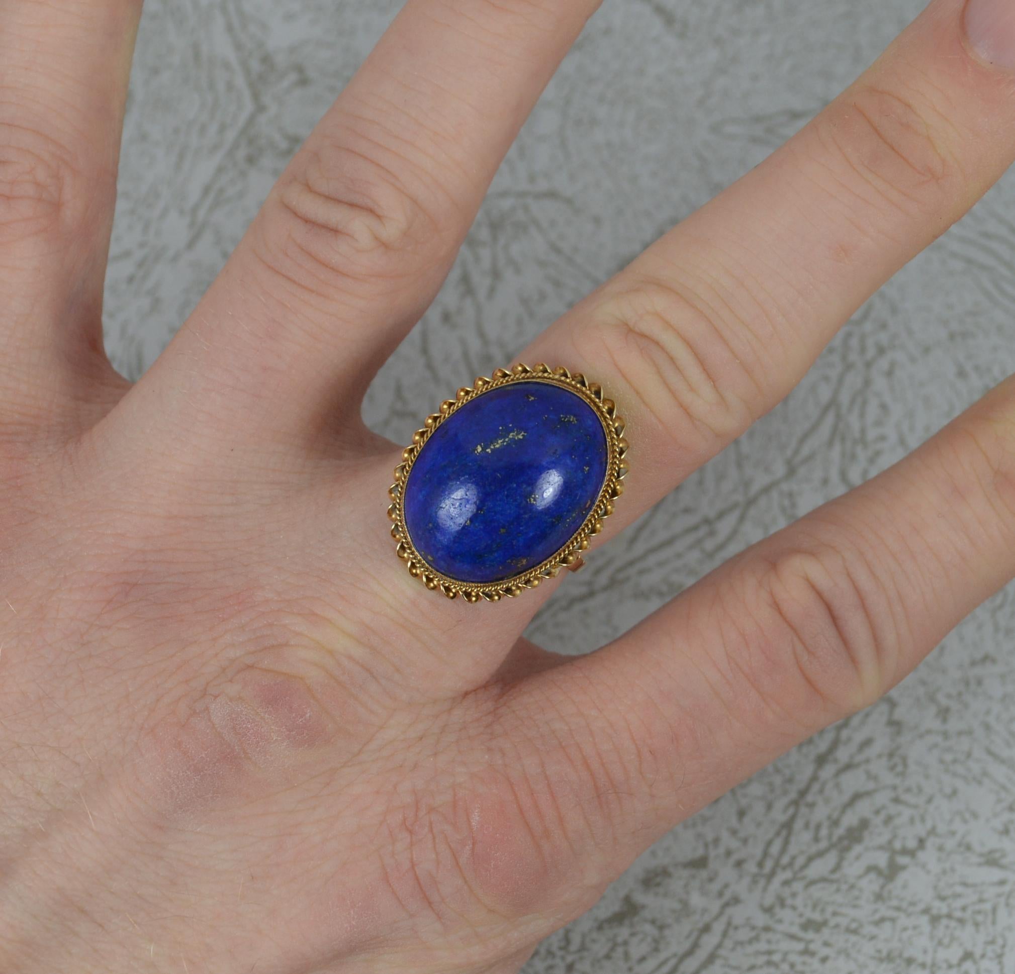 A stunning ladies solid 9 carat yellow gold and lapis lazuli ring.
Set with an oval shaped lapis lazuli, 15mm x 20mm with gold rope twist border surround.
Protruding 9mm off the finger.

Condition ; Very good. Crisp design. Solid piece. Well set