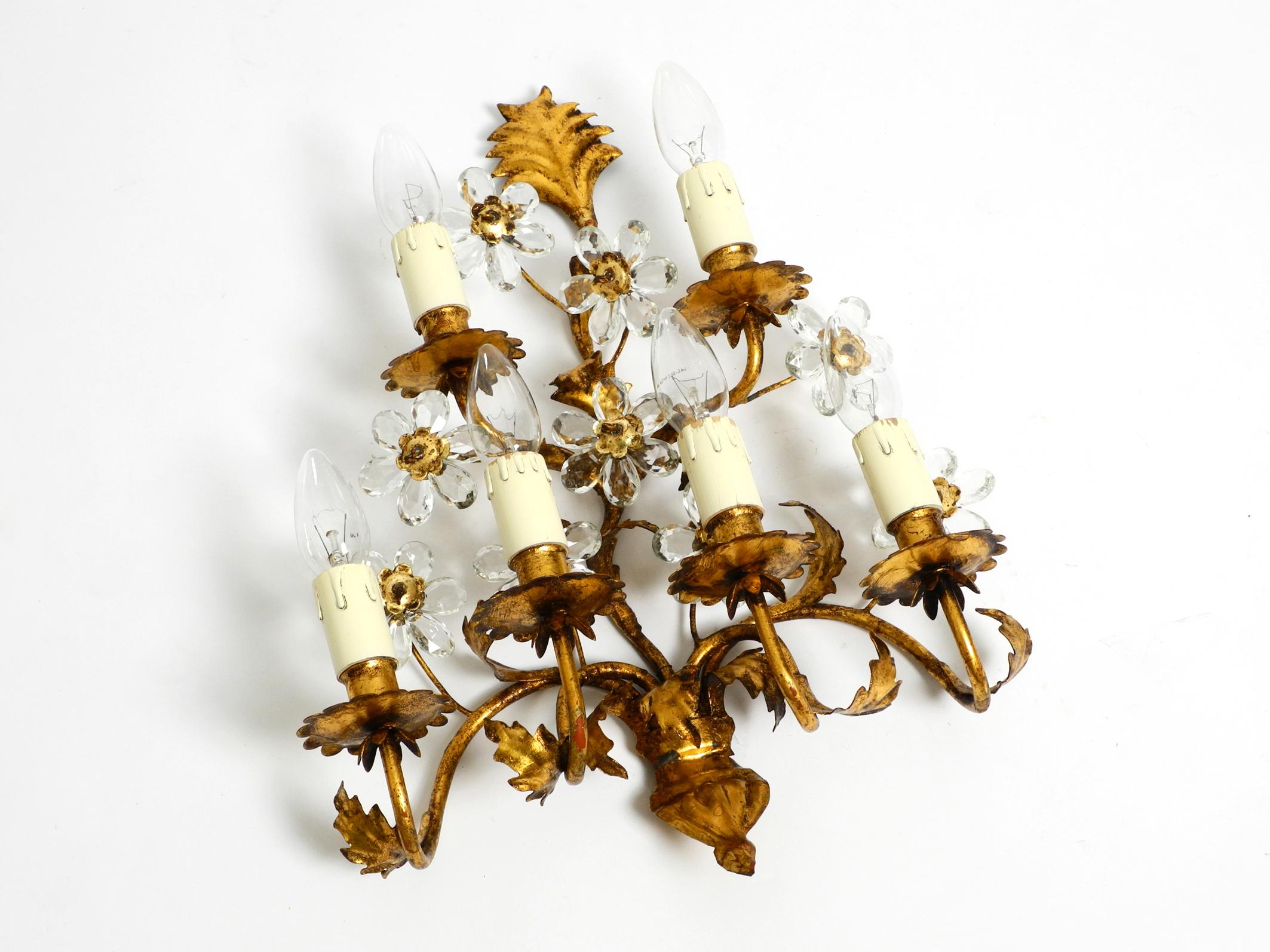 Beautiful large 1960's Italian gold plated wall lamp with six sockets.
Manufacturer is Banci Firenze. Made in Italy.
Very elegant design with transparent crystal glass flowers and frame made of gold-plated metal.
Fully functional with six E14