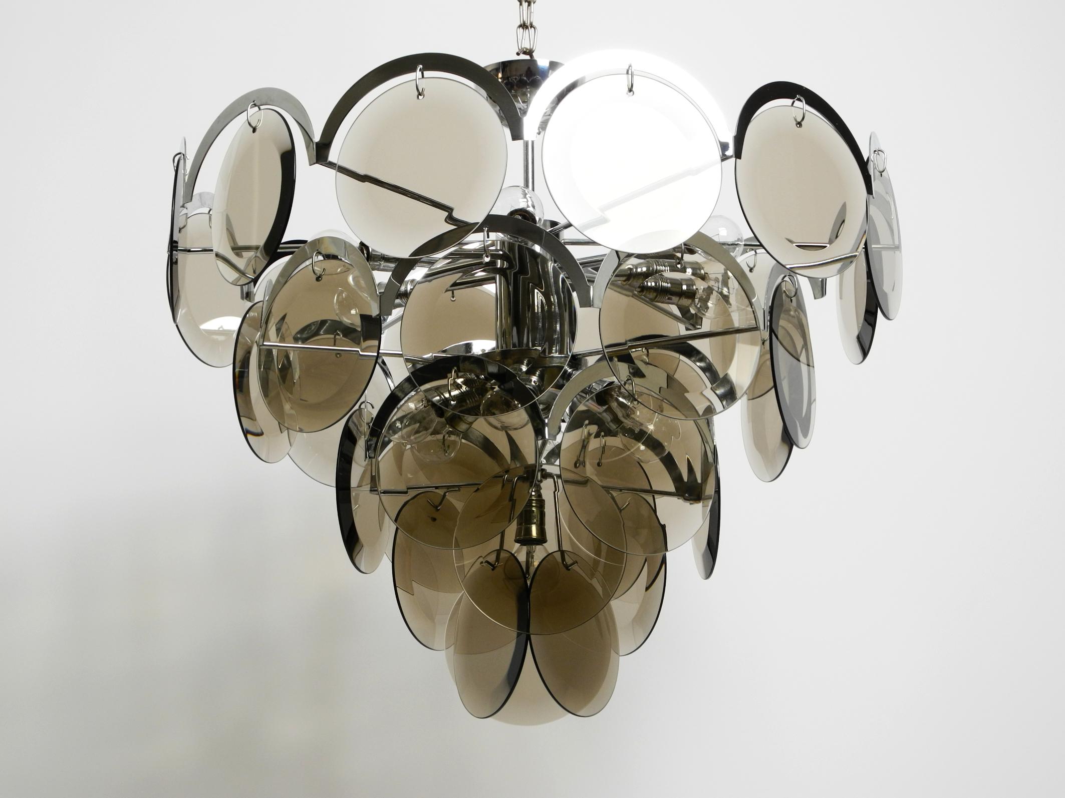 Beautiful very large original 1960s large ceiling chromed chandelier with lots of grey smoked glass discs.
Great Space Age design. Made in Germany.
Very high quality lamp for a great enchanting light for every room. The frame with the sockets is