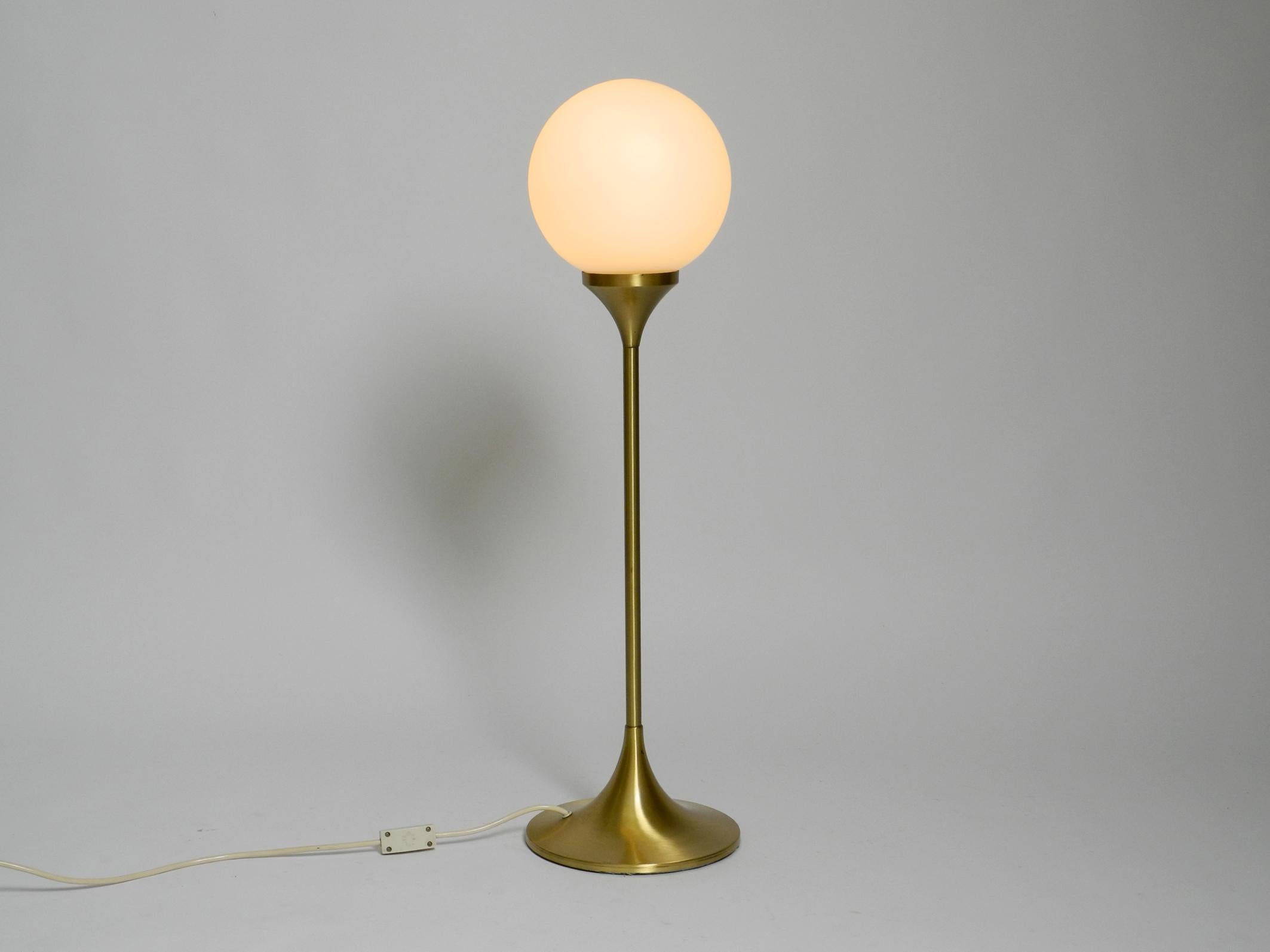 Beautiful large 1960s heavy metal table or floor lamp in brass color.
The manufacturer is Sölken Leuchten. Made in Germany.
White frosted glass lampshade. Makes a very nice soft light.
Great Mid Century Space Age design with lots of details and very