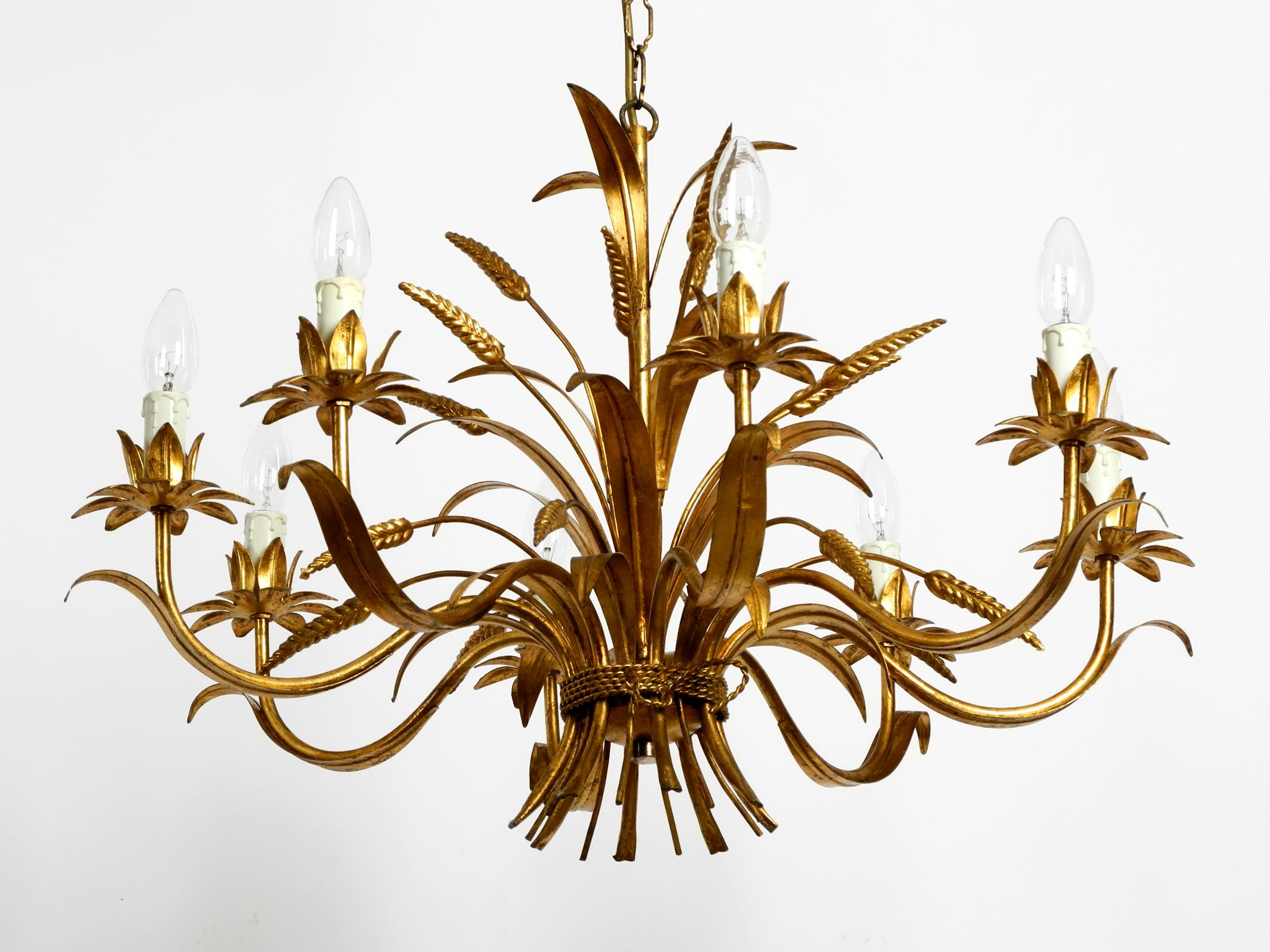 Beautiful, large 1970s gold-plated 8-arm metal chandelier by Hans Kögl.
Hans Kögl was a famous light and table designer. 
He worked with natural shapes like palm leaves and plant shapes. 
His designs were produced in both Germany and Italy.