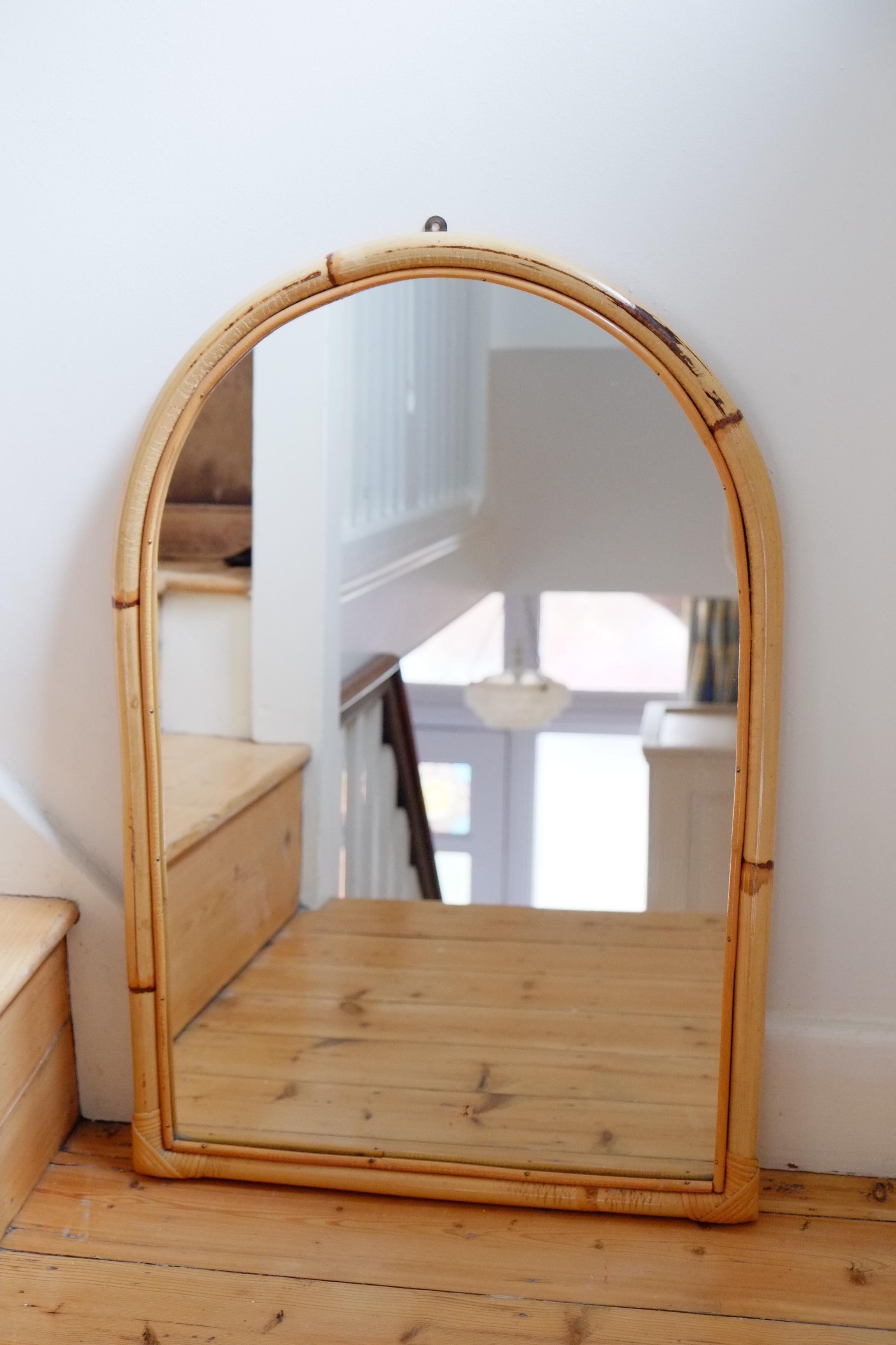 A beautiful large midcentury mirror with a bohemian bamboo frame. The frame has an arched top and a double bamboo frame with tiny brass pins holding the slimmer bamboo in place. This piece would look amazing in a hallway or bathroom. 

Measure: 51
