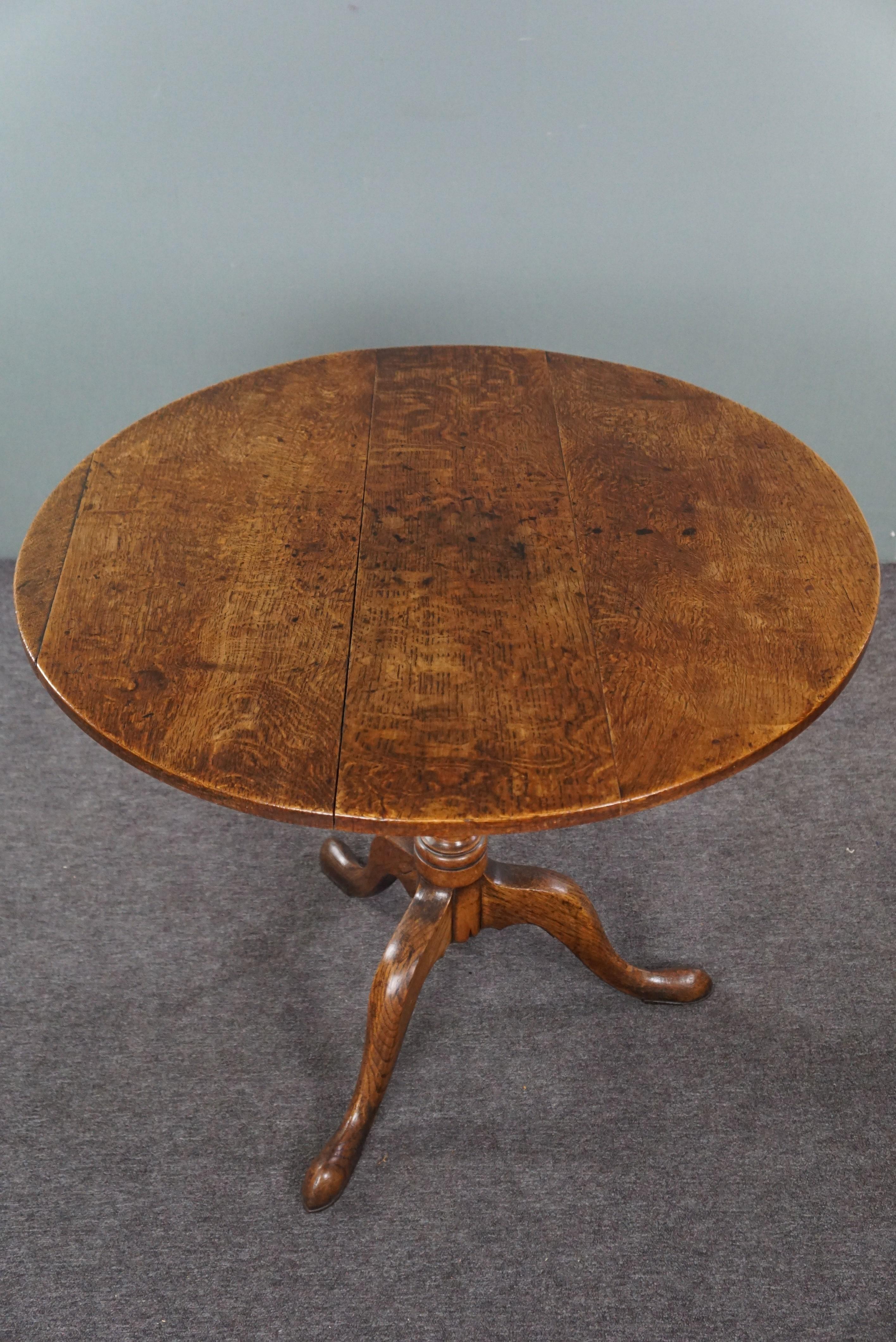 Offered is this beautiful large 18th-century English oak tilt-top table with warm colors. This magnificent large English tilt-top table is in good and proper condition. Due to its folding mechanism, it's easy to fold up and put aside should extra