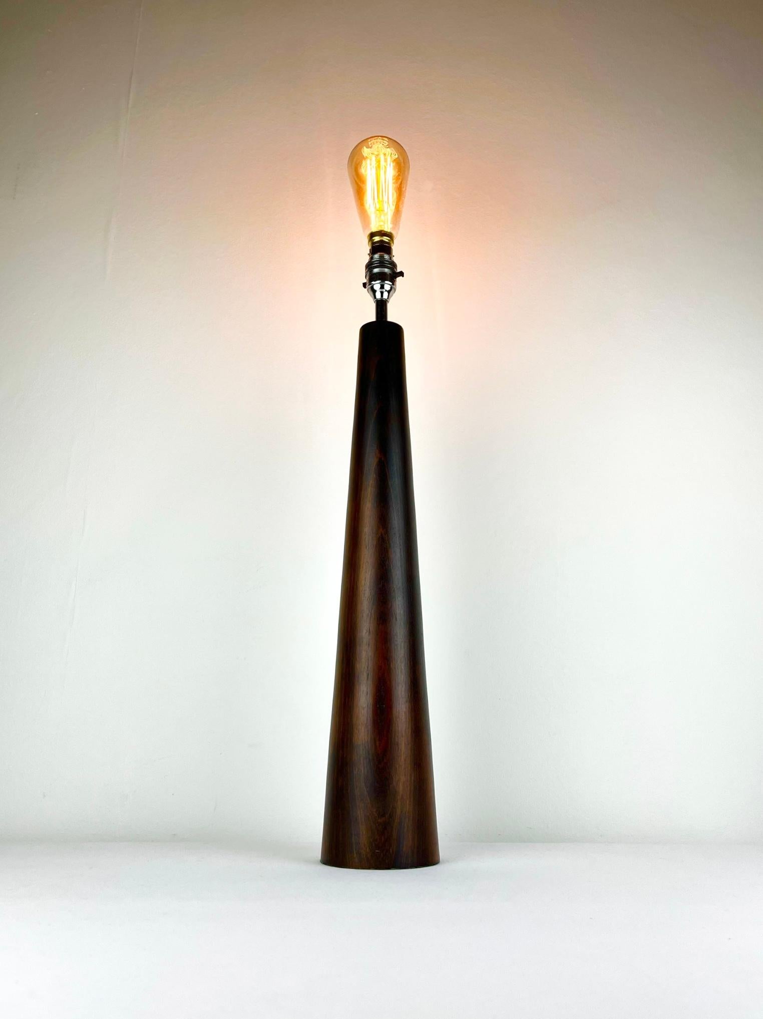 A beautiful and large Danish rosewood conical lamp.
Turned from a single piece of wood, it stands nearly 1/2 a metre tall and elegantly tapers towards the shiny chrome lamp-holder at the top.
Rewired with 225cm of vintage bronze style braided cable,