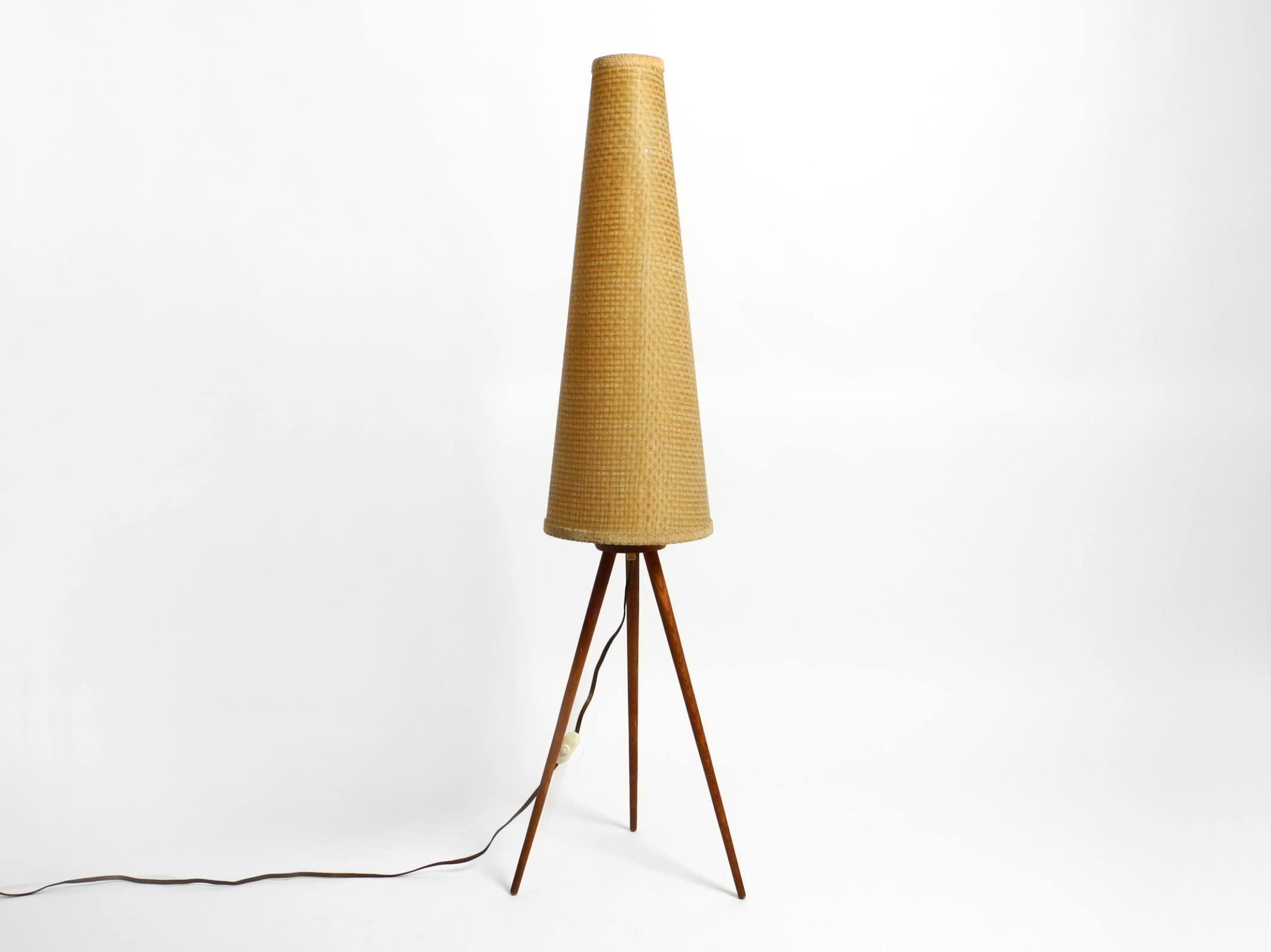 Beautiful mid-century modern tripod floor lamp. Legs and frame made of teak. With large original lampshade.
Very rare minimalist 1950s design. Made in Germany.
Makes a very pleasant warm light. Very good original vintage condition.
The shade is