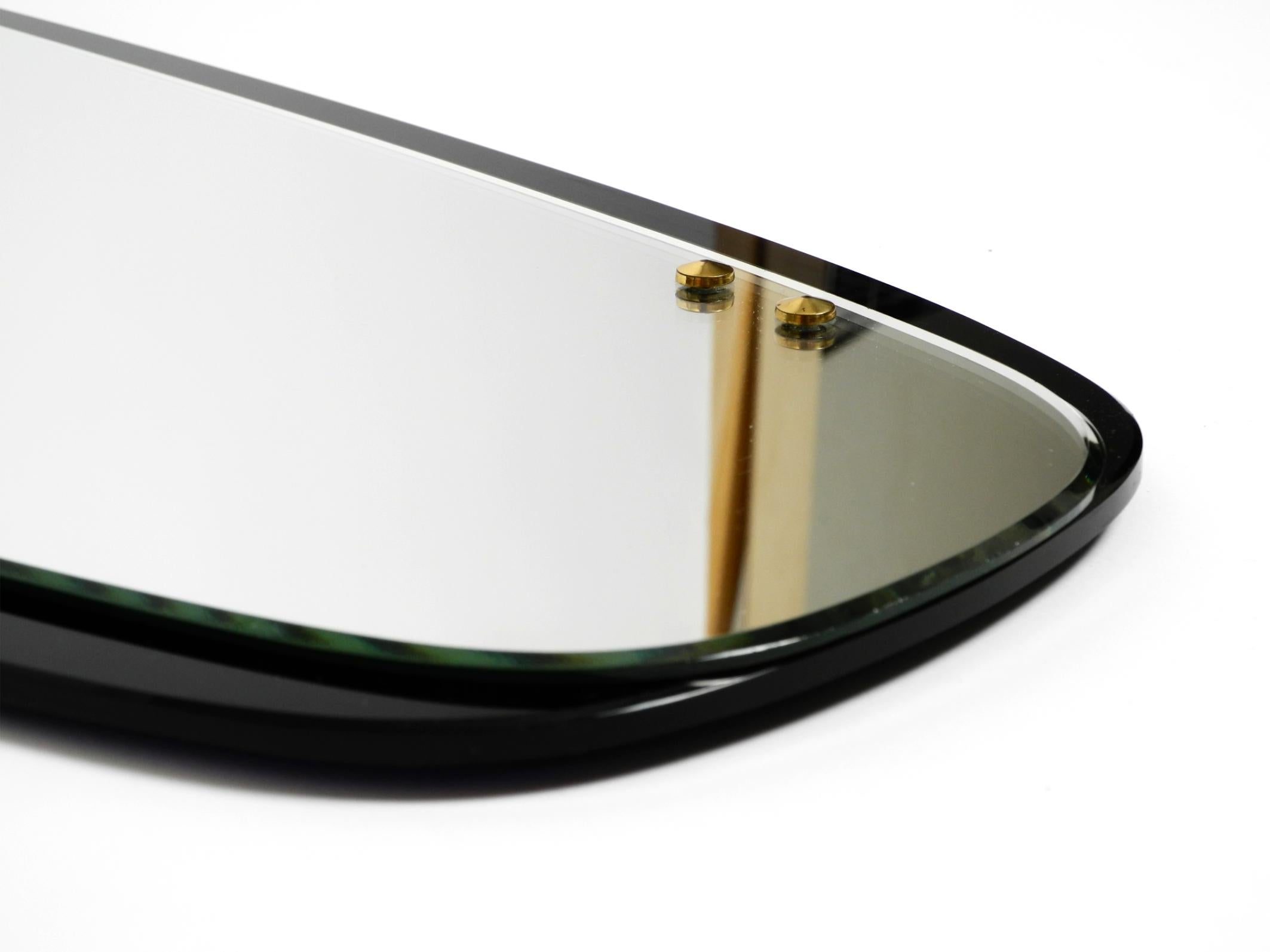 Schöner großer Mid Century Wandspiegel mit außergewöhnlichem schwarzem Glasrahmen im Angebot 3