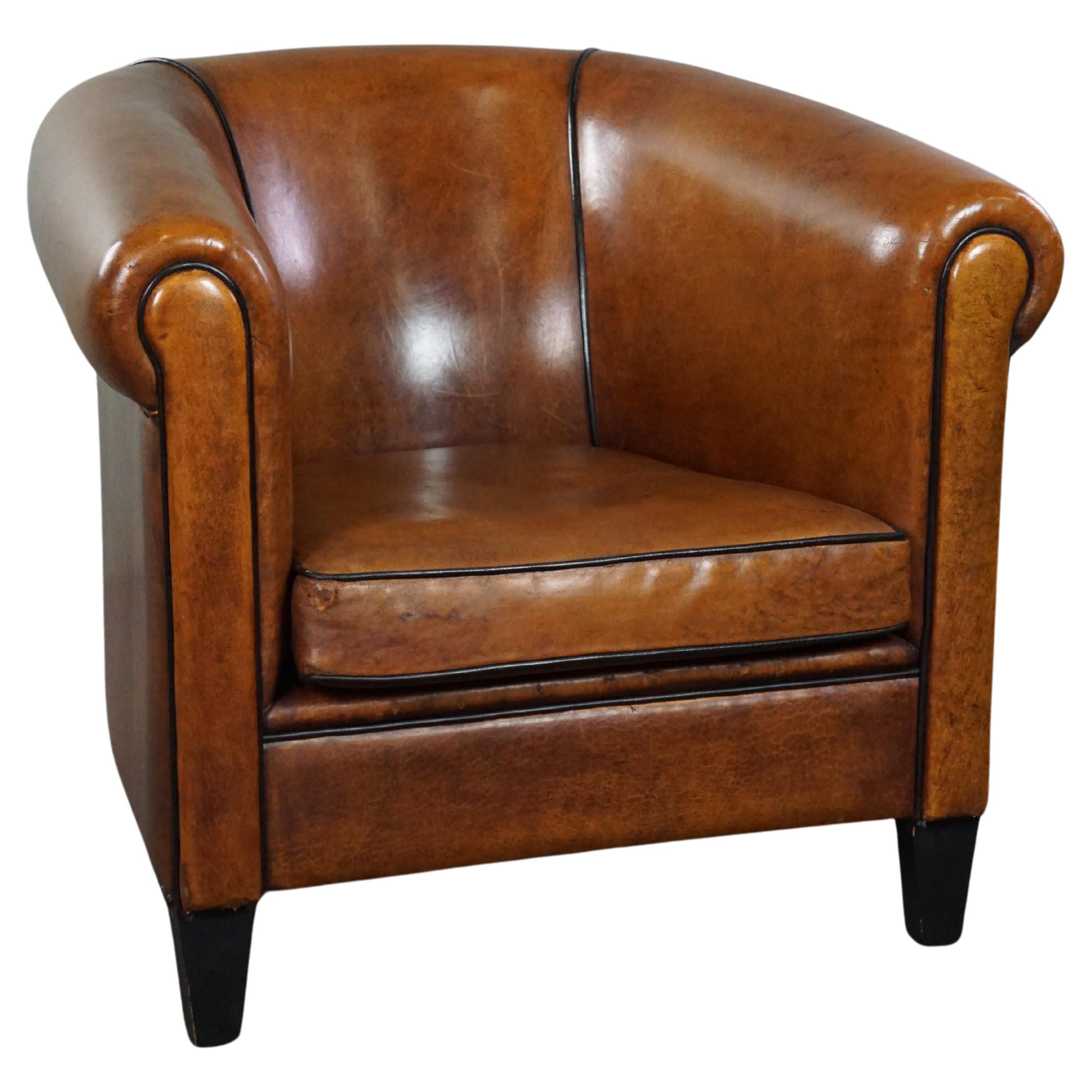 Magnifique fauteuil club en cuir de mouton de grande taille avec finition en passepoil noir