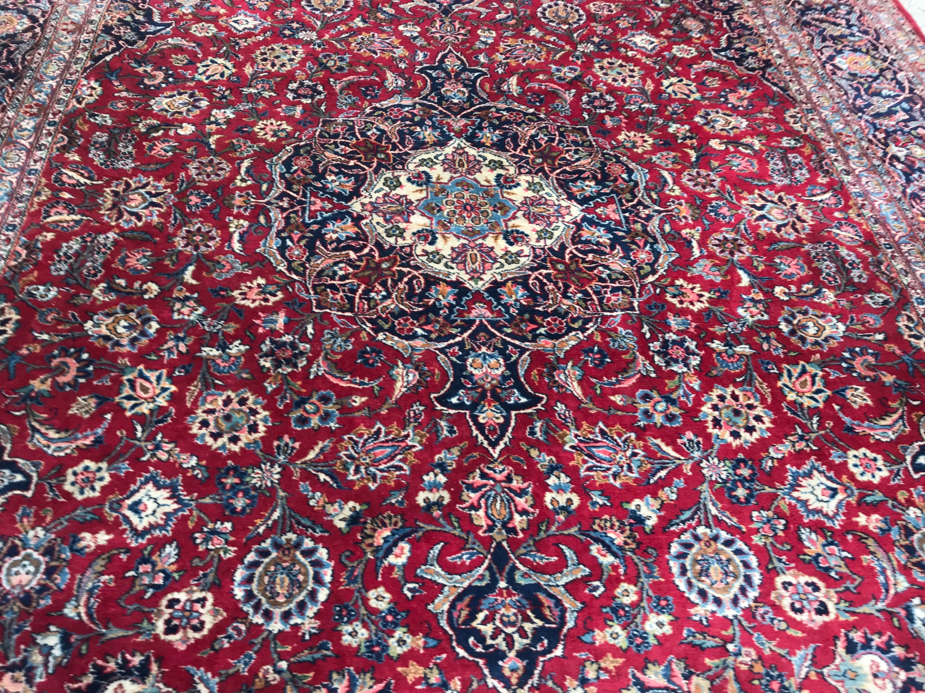 Nice large mid-20th century rug with beautiful floral design, a central medallion and nice red field color with dark blue, light blue, green, yellow and pink, entirely hand knotted with wool velvet on cotton foundation.