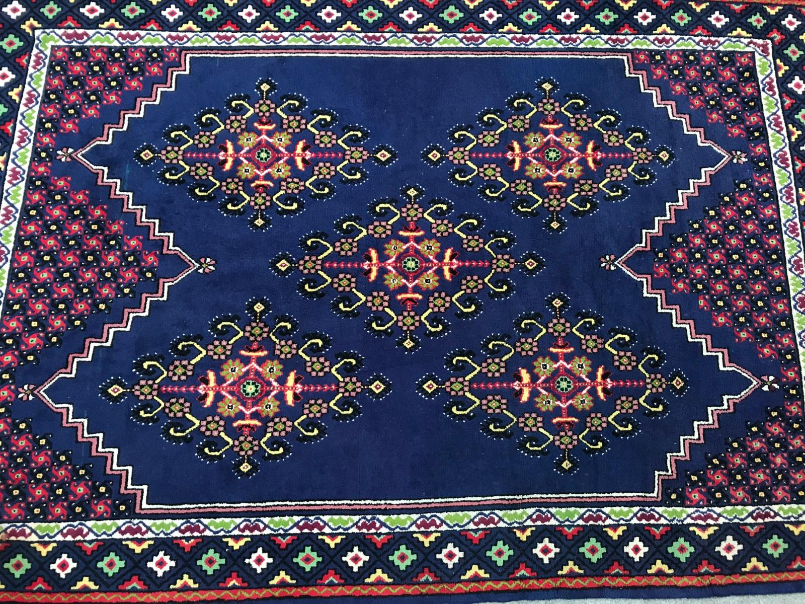 Beautiful 20th century rug from Tunisia very decorative with a tribal geometrical design and nice colors with a blue field, pink, yellow and green, entirely hand knotted with wool velvet on cotton foundation.
  
