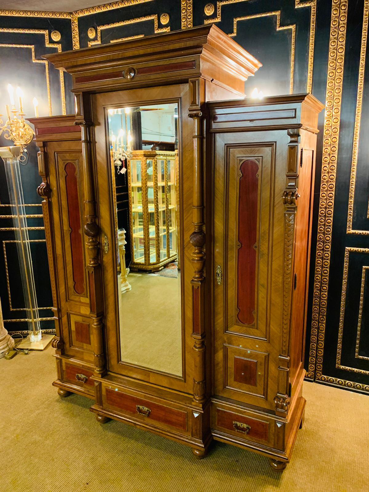 Beautiful large Wilhelminian style wardrobe - Berlin from around 1880 in walnut & solid oak. The cabinet as well as the entire veneer is in a very nice, original, well-kept condition. The entire upper cornice, pillars, cornice, feet, faceted