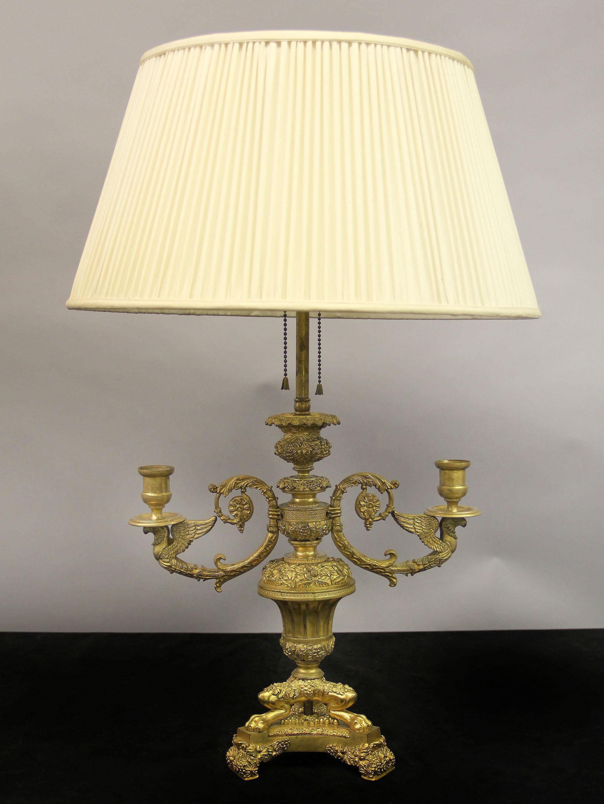 Preciosa lámpara bouillotte de bronce dorado estilo Imperio de finales del siglo XIX

Lámpara de bronce de fantástica calidad totalmente cincelada con bayas y flores, dos brazos en forma de C se extienden con grifos alados y candelabros, la parte
