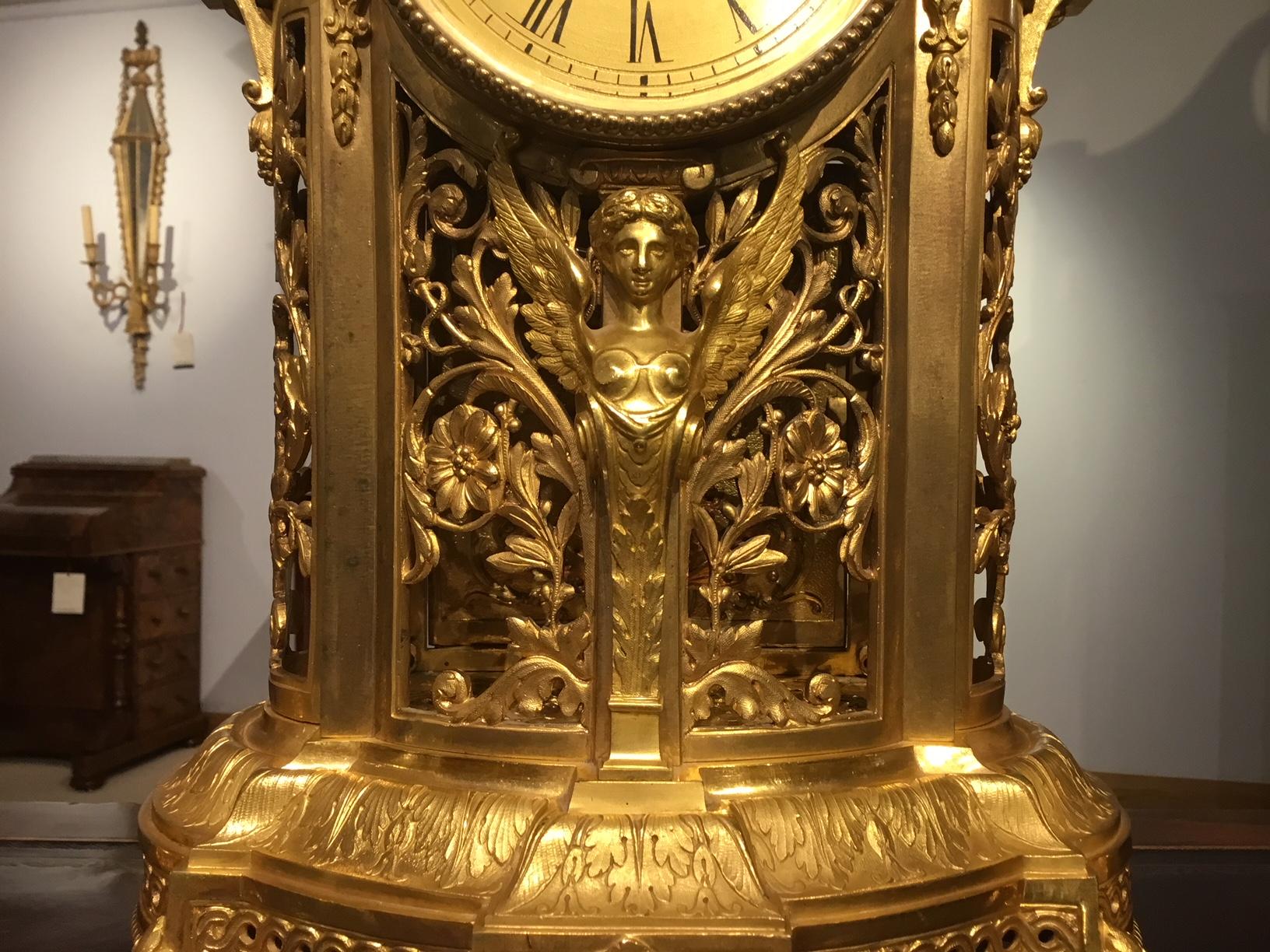 A beautiful late 19th century French ormolu clock garniture with a Japy Freres movement. The central clock having a circular dial with Roman numerals, striking on the quarter, half and hour, above a winged angel, with a pierced case having acanthus