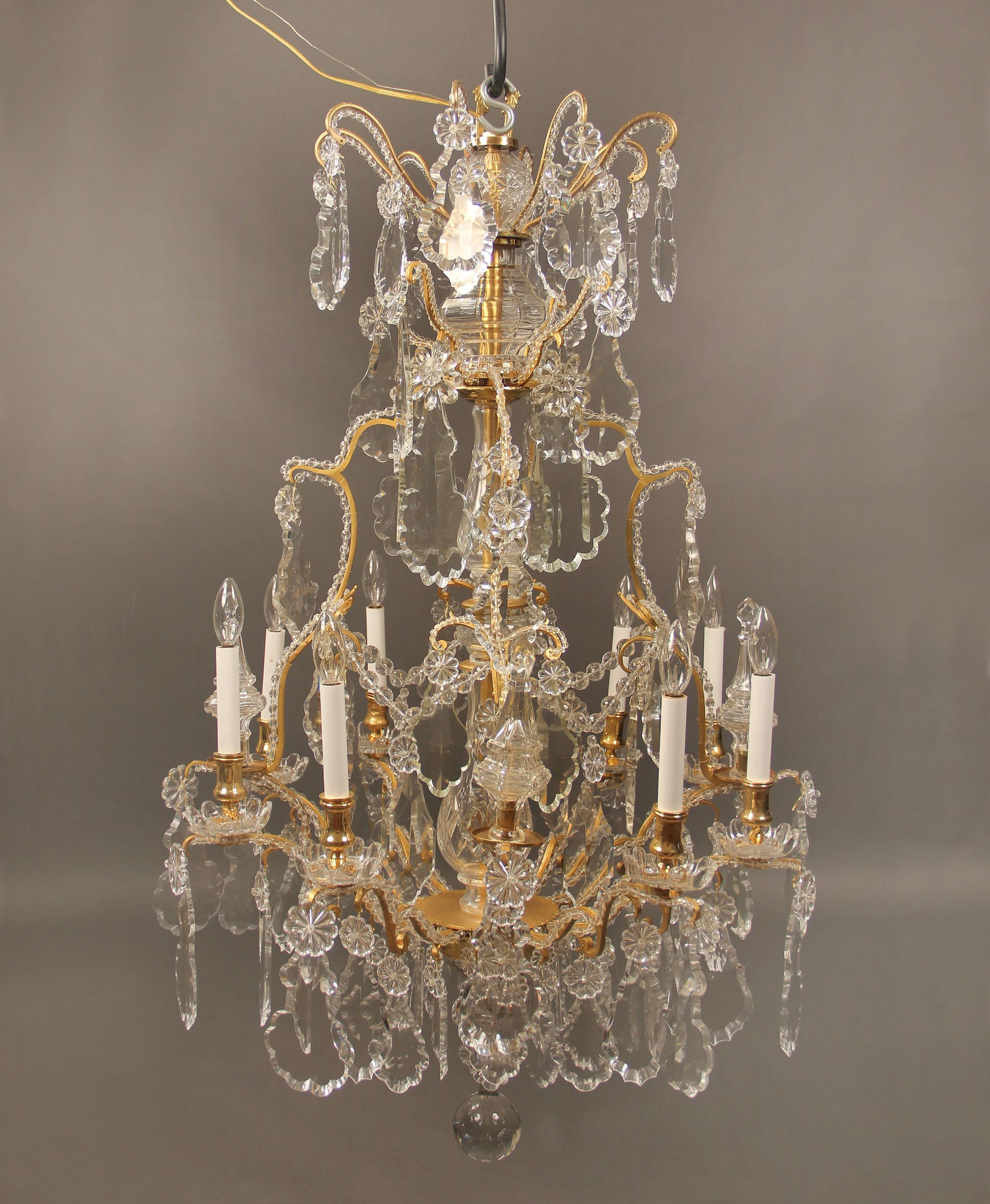 A beautiful late 19th century gilt bronze and crystal eight-light chandelier.

Multi-faceted and shaped crystal, cut crystal central column with beaded arms and swags, four spears and eight perimeter lights.