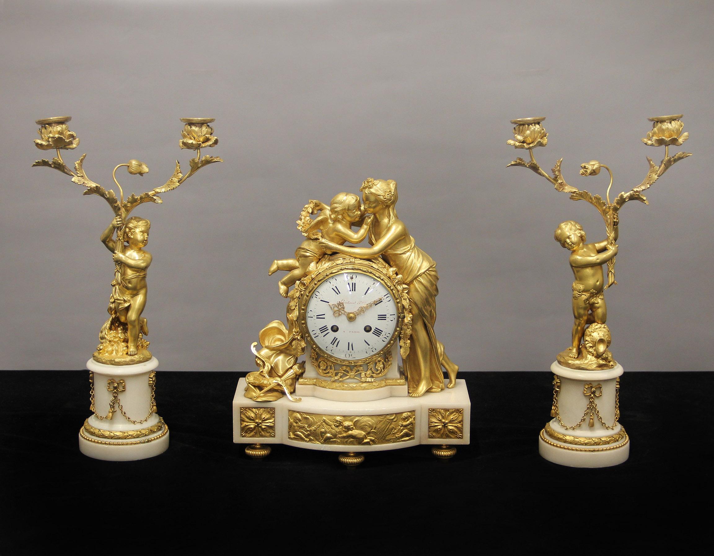 A Beautiful Late 19th Century Gilt Bronze and Marble Three Piece Clock Set – Lieutaud Paris

The excellent quality clock case in white marble with figures of Venus and Cupid embracing, surrounded by roses and garlands, the base with a bronze plaque