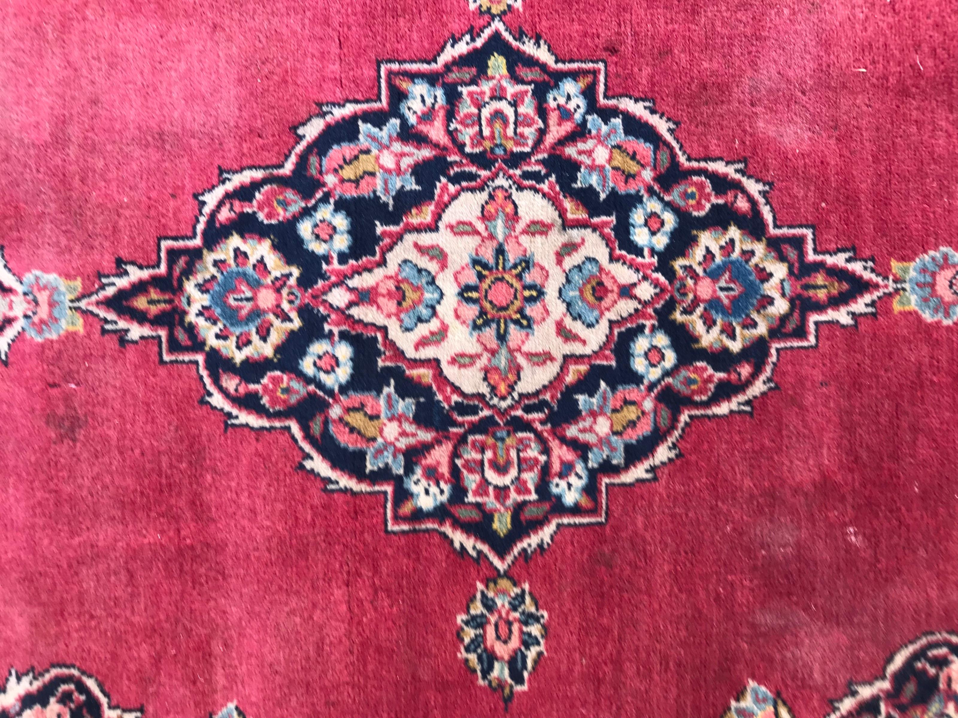 Mid-20th century little rug with beautiful central medallion design and red field color, entirely hand knotted with wool velvet on cotton foundation.