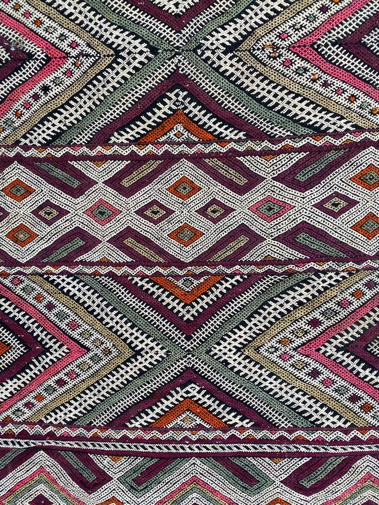 Very beautiful early 20th century tribal Moroccan Kilim, with a geometrical Berbere design and nice colors with green, purple, pink and orange, entirely handwoven with wool on wool foundation.