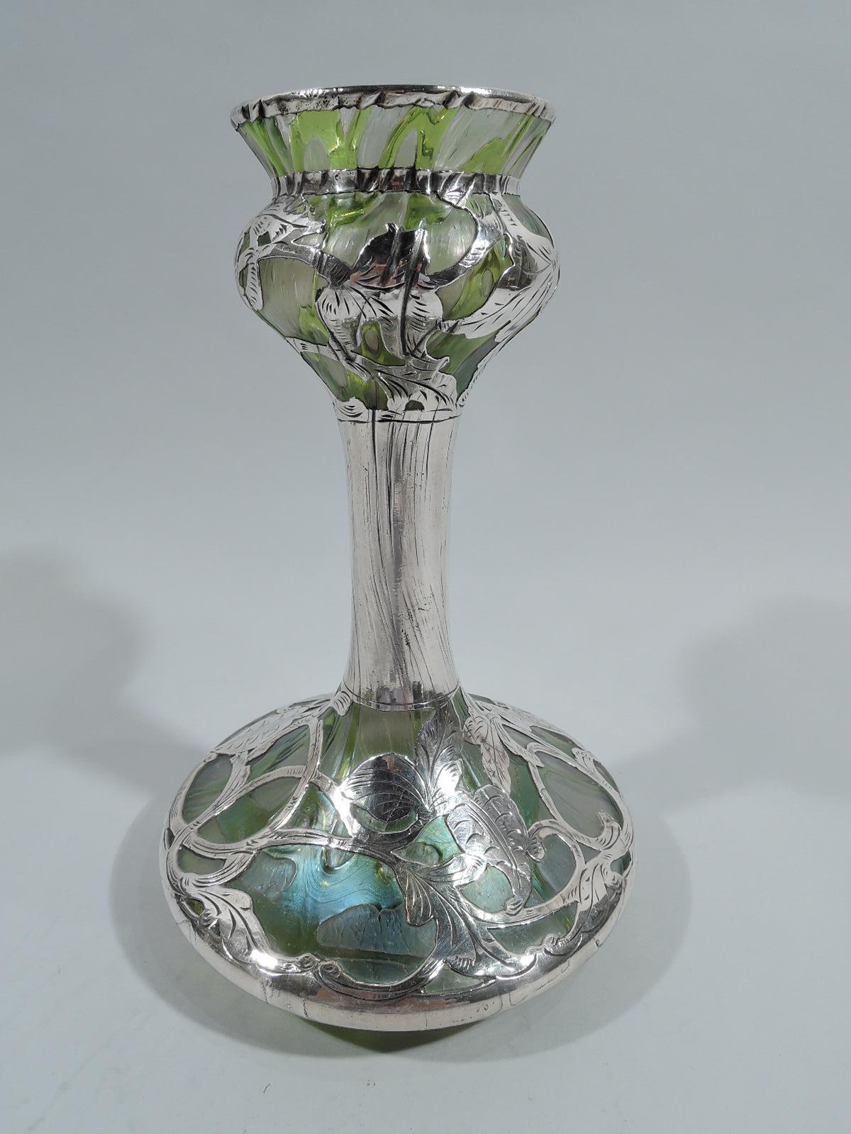 Beautiful turn-of-the-century Art Nouveau glass vase by historic Loetz with engraved silver overlay. Round and tapering bowl with flared rim, tall cylindrical shaft, and wide bellied bowl. Interlay in form of leaves with entwined and scrolling