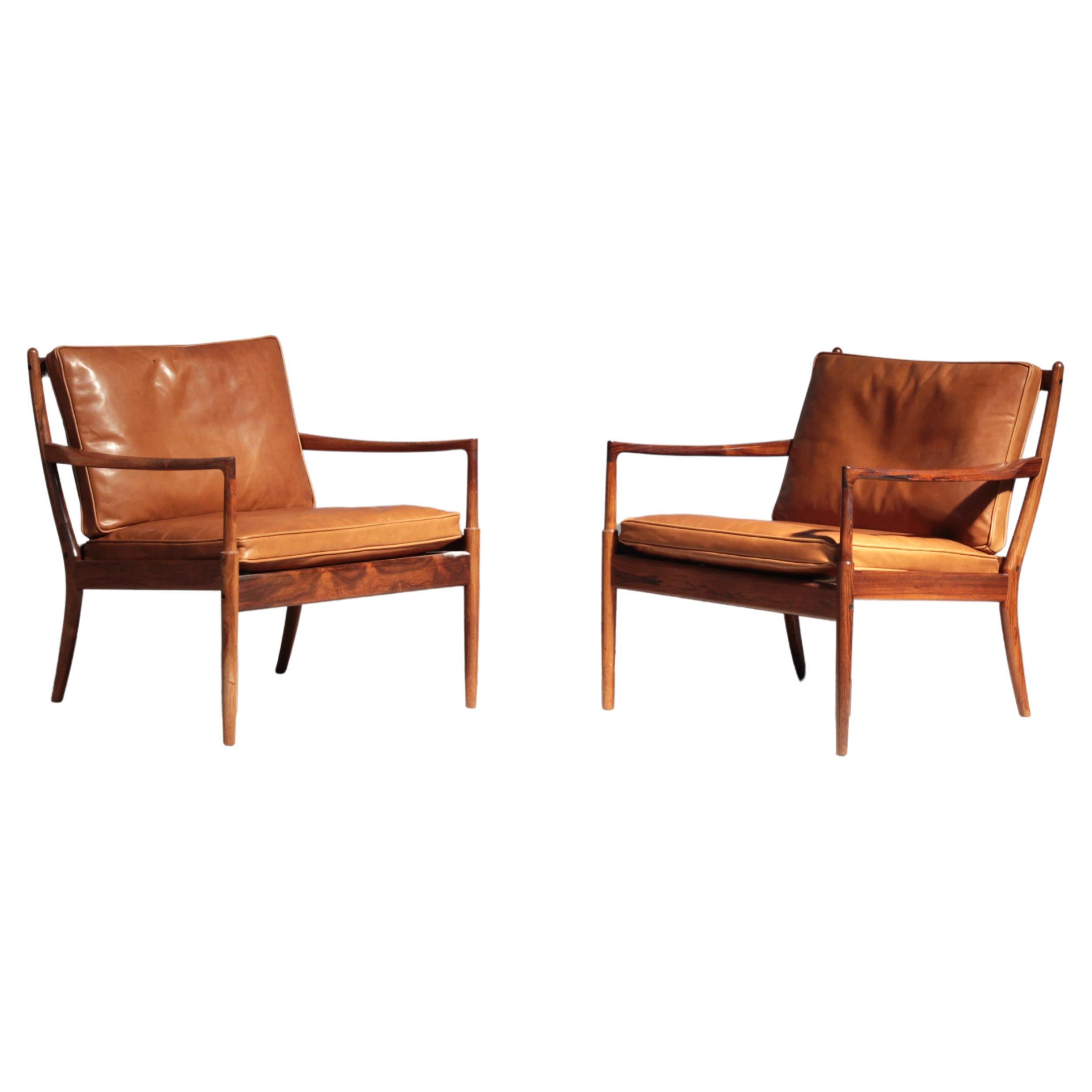 Beautiful pair of lounge chairs designed by the Danish designer Ib Kofod-Larsen in 1958 for the Swedish furniture manufacturer OPE Mobler, Sweden. Both chairs are made out of rosewood and leather cushions in brown-cognac. Both are in excellent