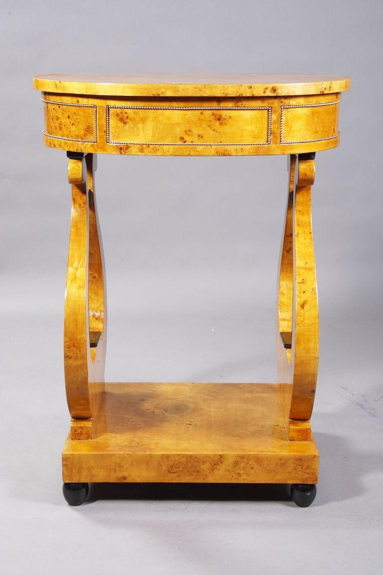 Maple root on solid softwood. Oval, one-piece frame bordered with brass beading on lyre-shaped, openwork cheeks with metal sides. Rectangular pedestal ending in blackened ball feet. Upper drawer with compartments. Overhanging, oval plate. Beautiful