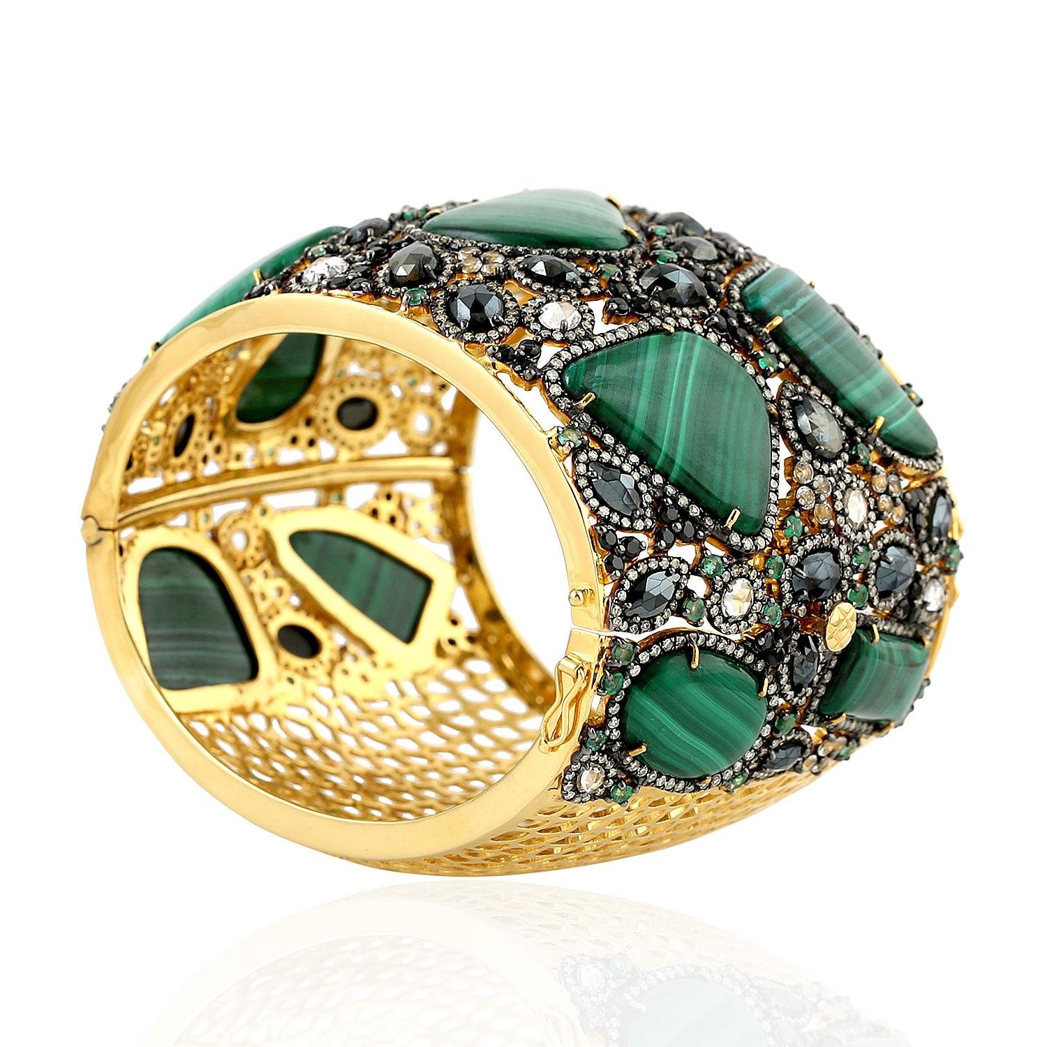Bold and beautiful sliced malachite decorated with diamonds emeralds in mosaic style. This bracelet cuff is broad and close with a tongue clasp on side.


18KT: 5.960gms
Diamond: 7.02cts
SiIver: 67.128gms
EMERALD: 2.25cts
MALACHITE:
