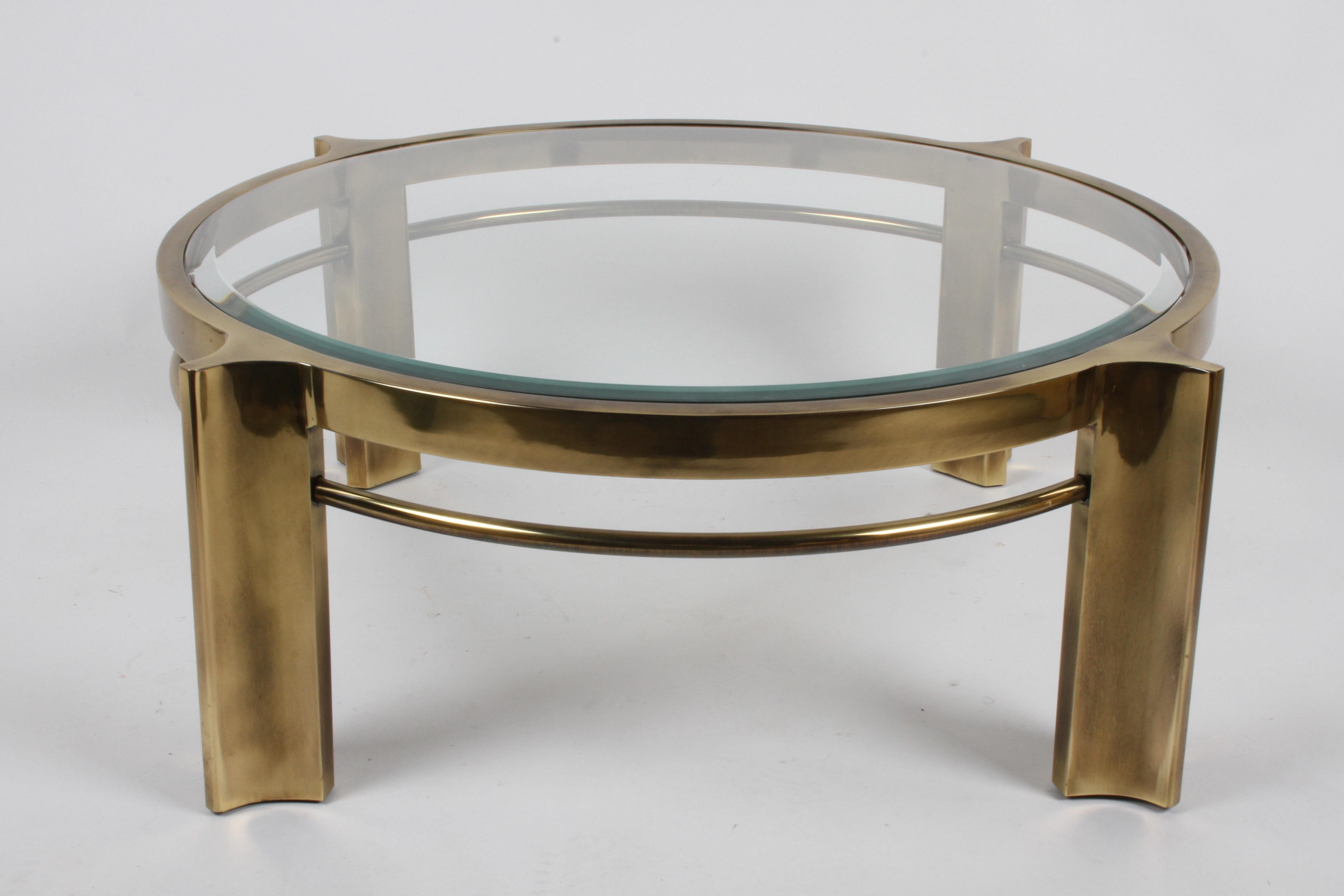 Rarely seen round coffee table by Mastercraft with glass bevel edge top on brass frame. The four legs are based off their 