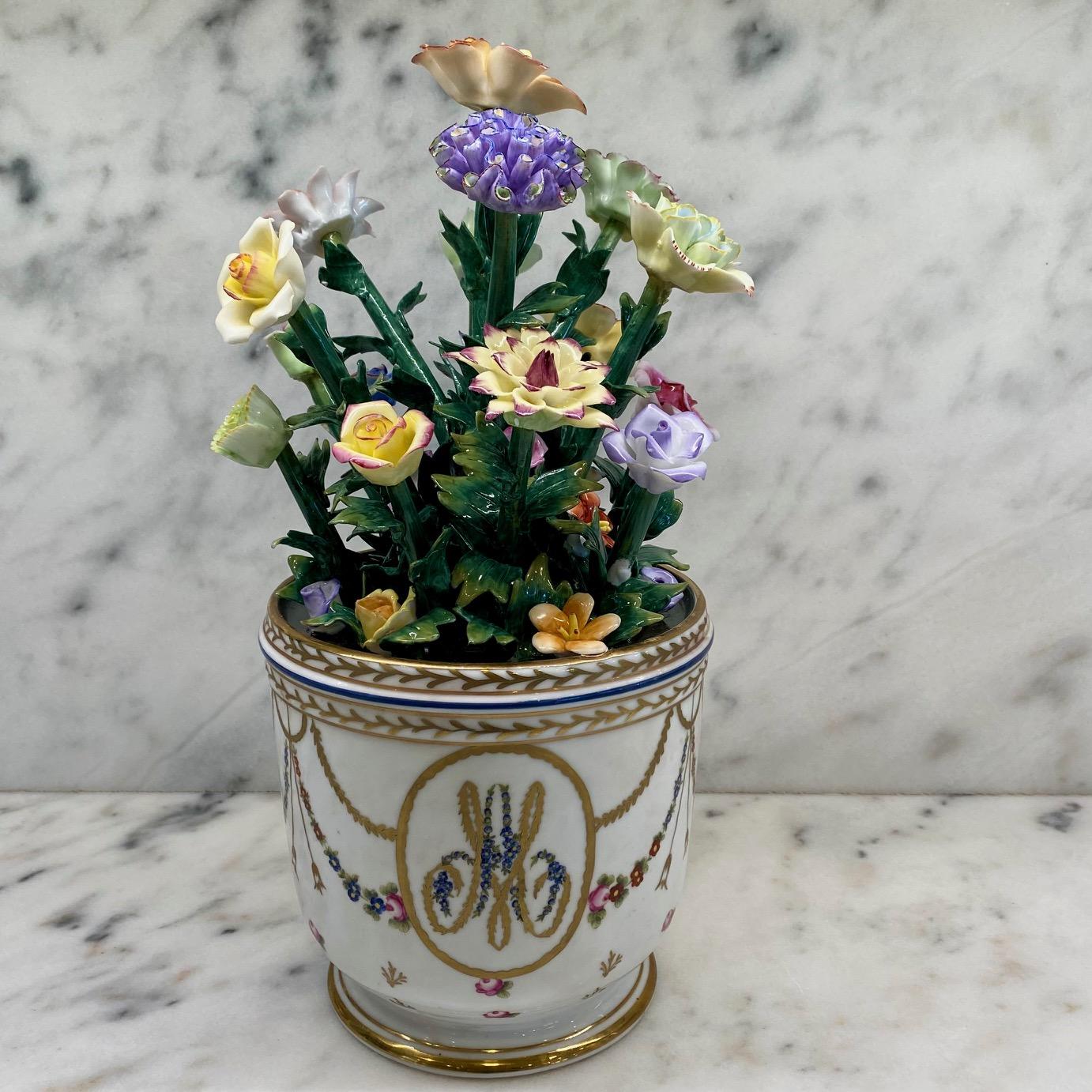 Museum quality French porcelain flower cachepot or flower vase, in Sevres porcelain decorated with garlands of flowers and gold foliage surmounted by a blue thread and gold thread with, in its center, the initials of Marie Antoinette. The whole is