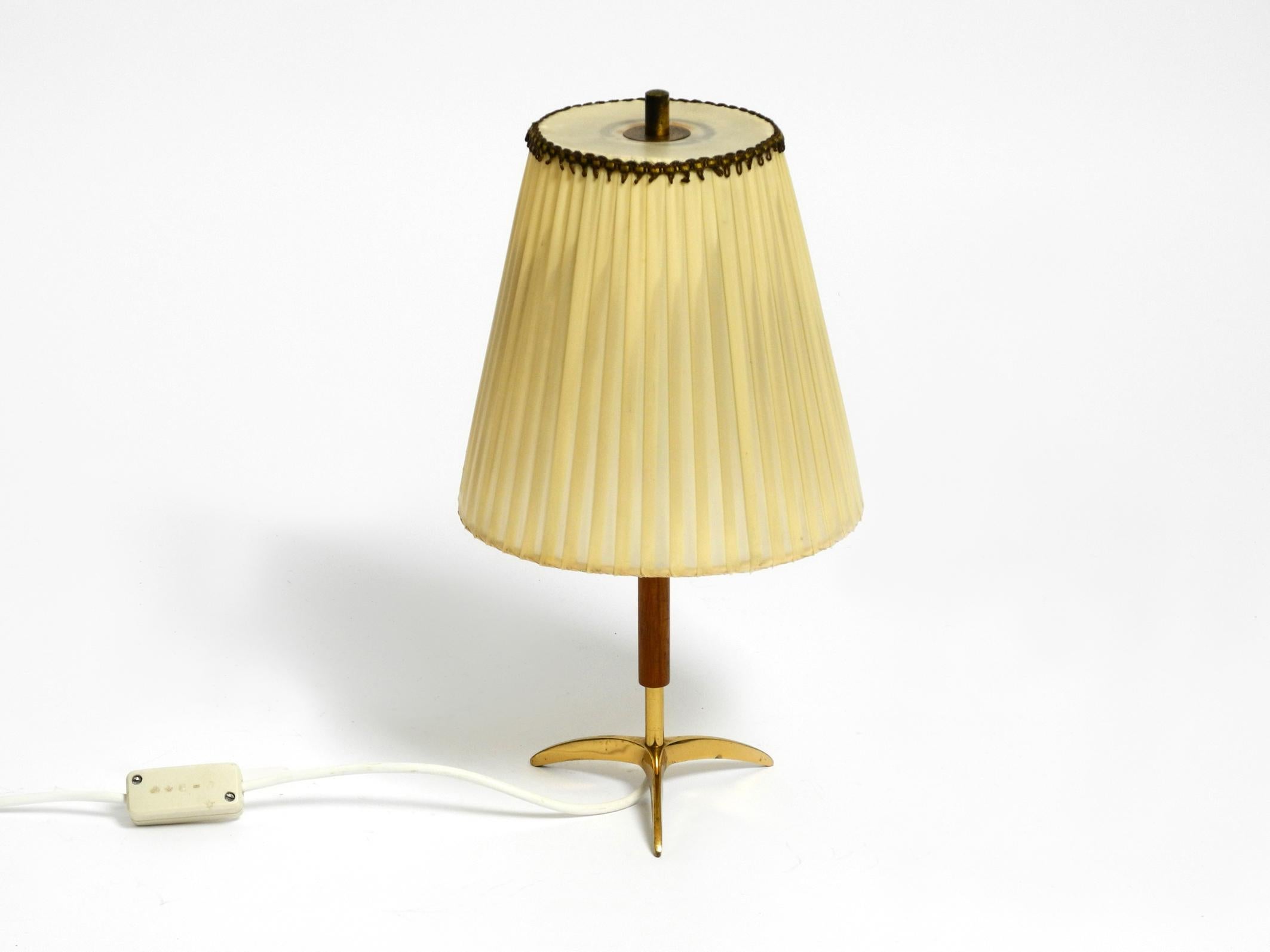 Beautiful small Mid Century brass table lamp with original pleated lampshade.
The shade is made of thin plastic, almost like a rough foil. Makes a beautiful light.
Made by Kalmar in the 50s. Made in Austria.
Very nice typical Mid Century design with