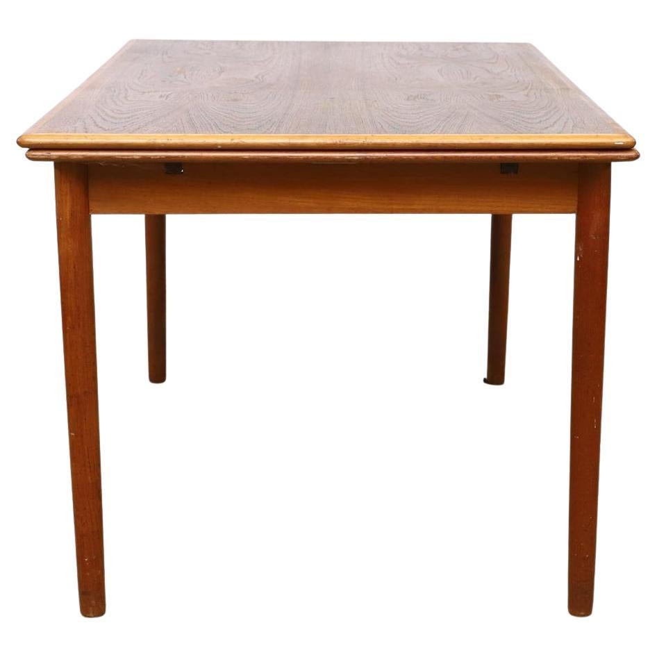 Mid century Danish Modern teak extension dining table Beautiful teak table that extends with (2) nesting pull out leaves. The leaves have carved handles under leaf to pull out. Solid teak round legs with a curved edge table top 50” x 34” x 29”. 