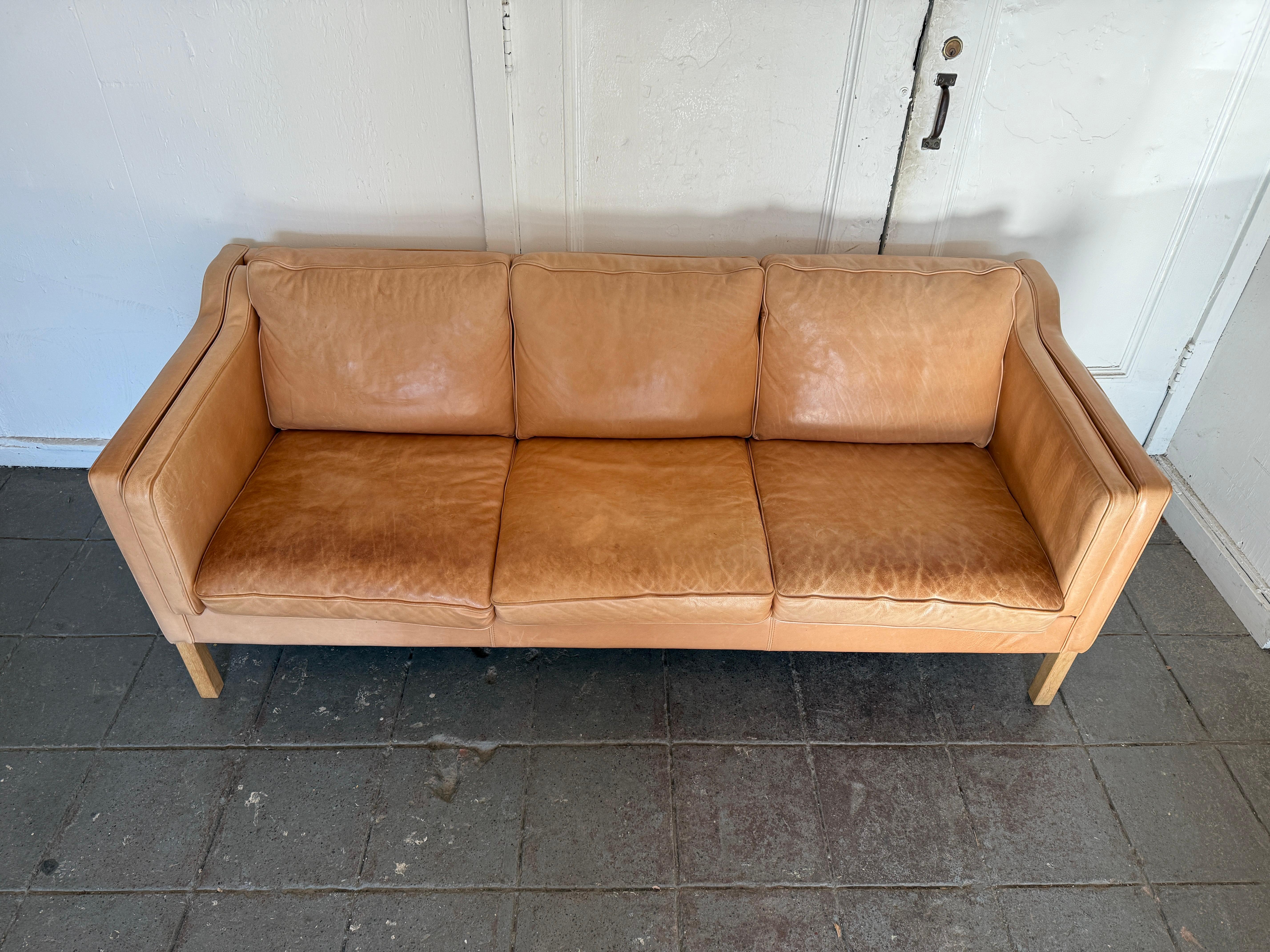 Great mid century Danish modern tan leather 3 seat sofa with Square white oak legs. Style of Børge Mogensen. Beautiful thick tan leather is soft and shows signs of use but broken in nicely. Tan leather shows fading, patina and scuffs from use. Great