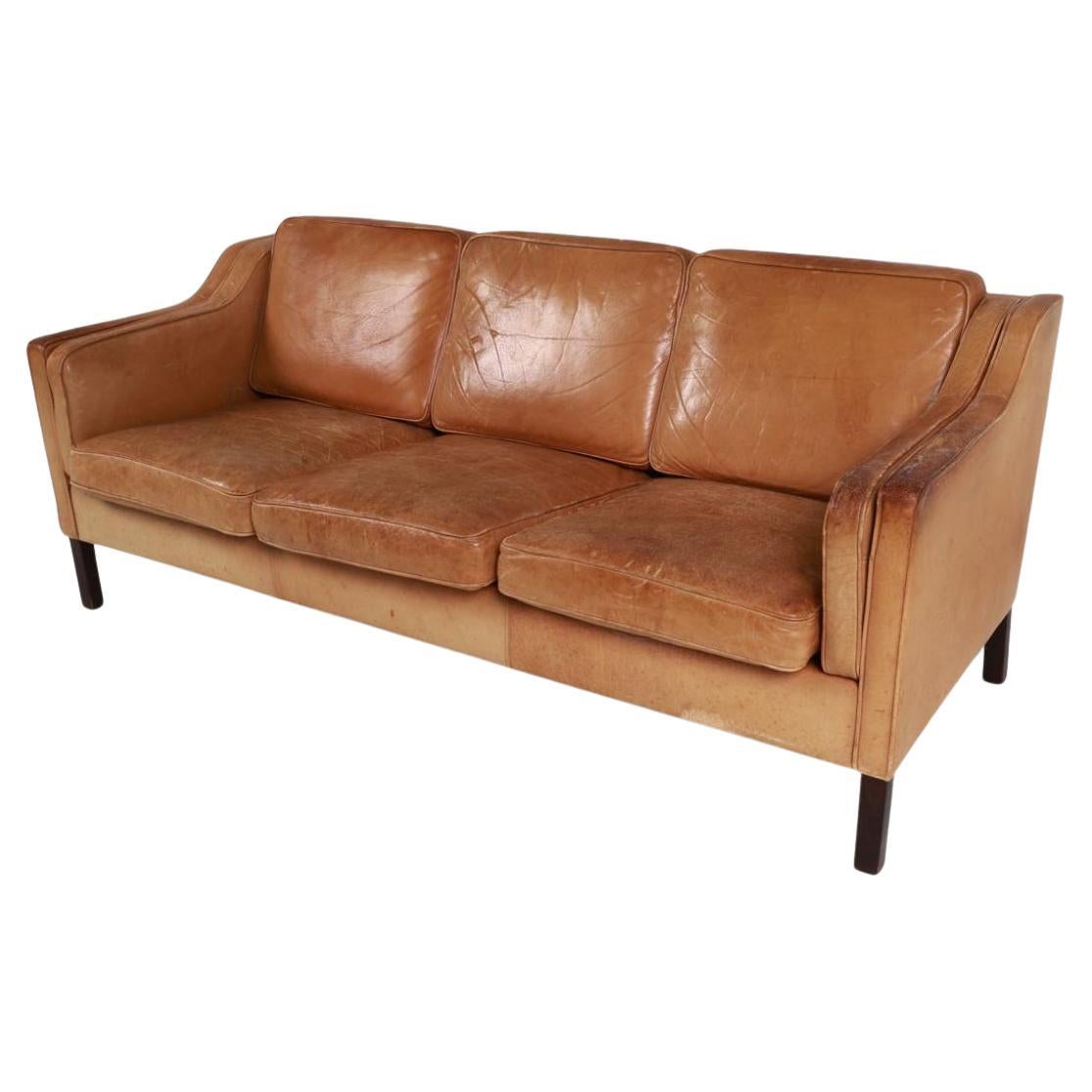 Great mid century Danish modern tan leather 3 seat sofa with Square dark wood legs. Style of Børge Mogensen. Nice thick tan leather is soft and shows signs of use but broken in nicely. Tan leather shows fading, patina cracking and scuffs from use.