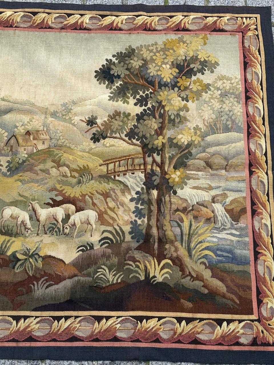 Discover the timeless elegance of this early 20th-century French Aubusson tapestry featuring a captivating design of a village.

This tapestry depicts a peaceful rural landscape with soft, muted colors. In the foreground, a winding path follows a
