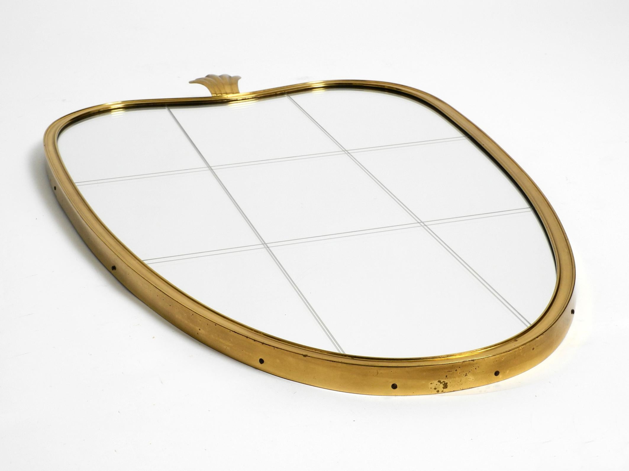 Beautiful heavy Mid Century Modern brass wall mirror.
Manufacturer is Münchner Zierspiegel. Made in Germany.
Great minimalist design. Beautiful patina on the brass.
The mirror glass is still original with the typical mill-cut from that time.
It was