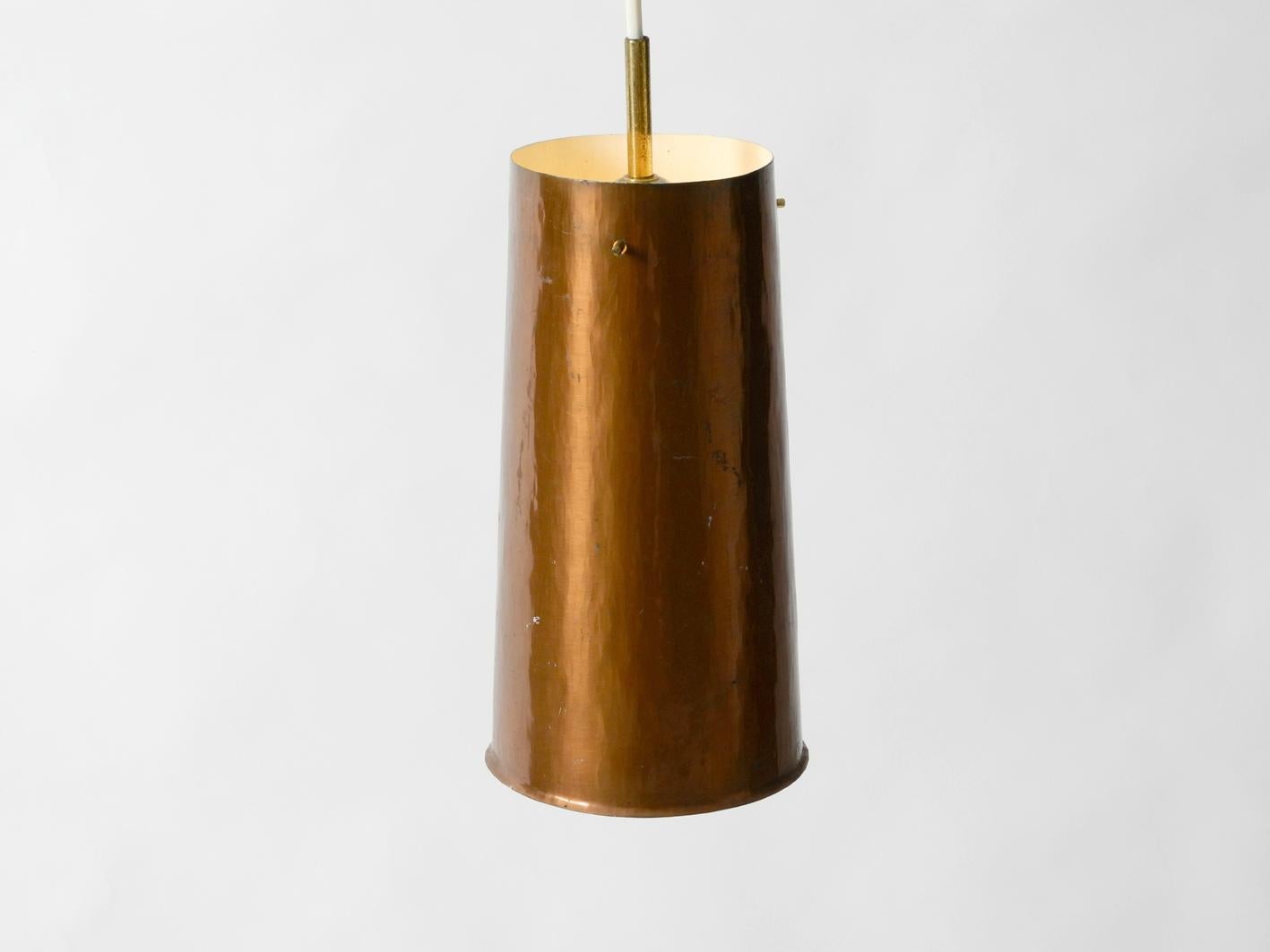 Beautiful Mid-Century Modern copper pendant lamp. Minimalistic 1950s cone design in very good original condition.
One original brass E27 socket. Very good vintage condition, no damages to the lamp, no bumps or dents. Great patina with very little